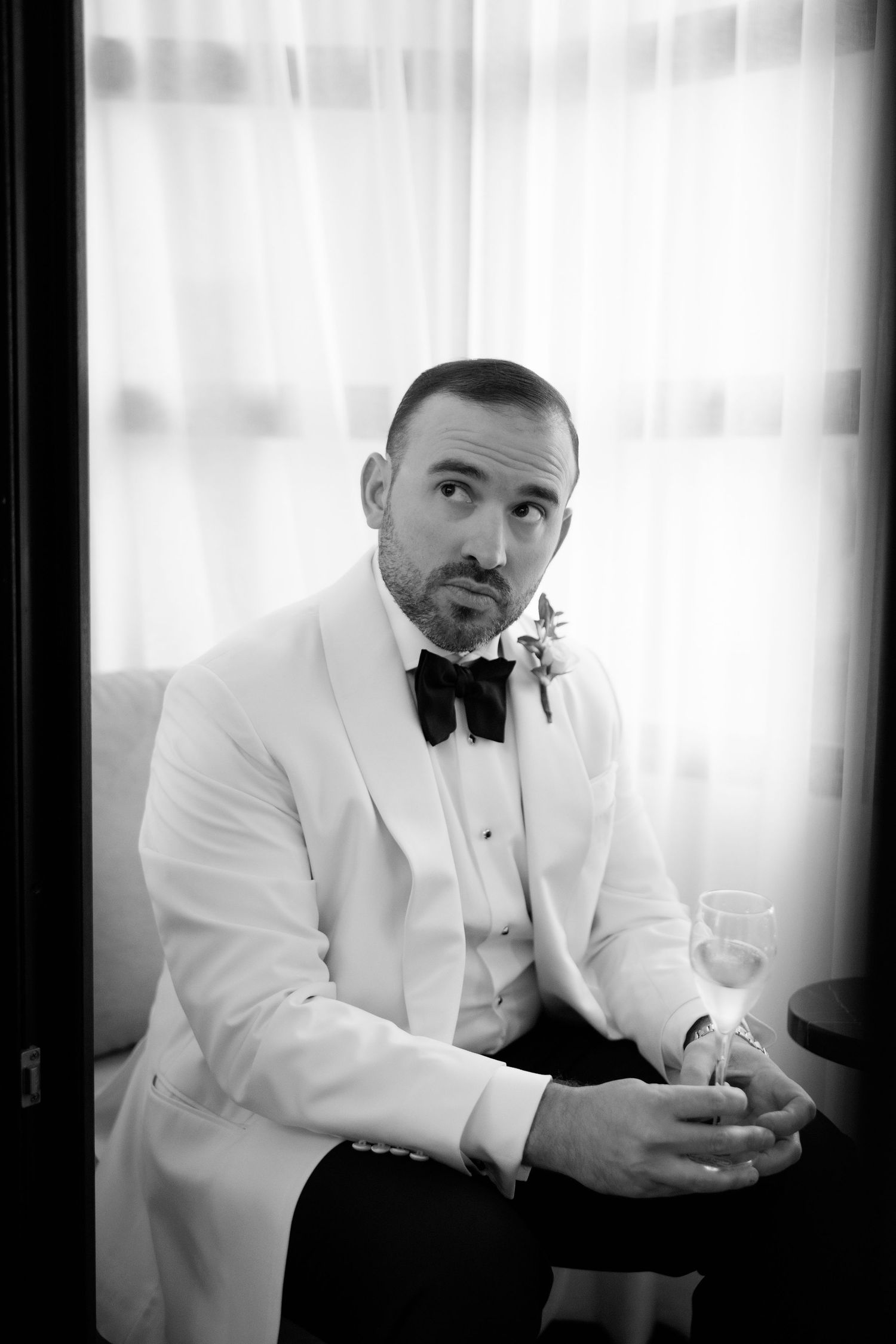 A series of black and white portraits showing a person in a white tuxedo jacket sitting thoughtfully.