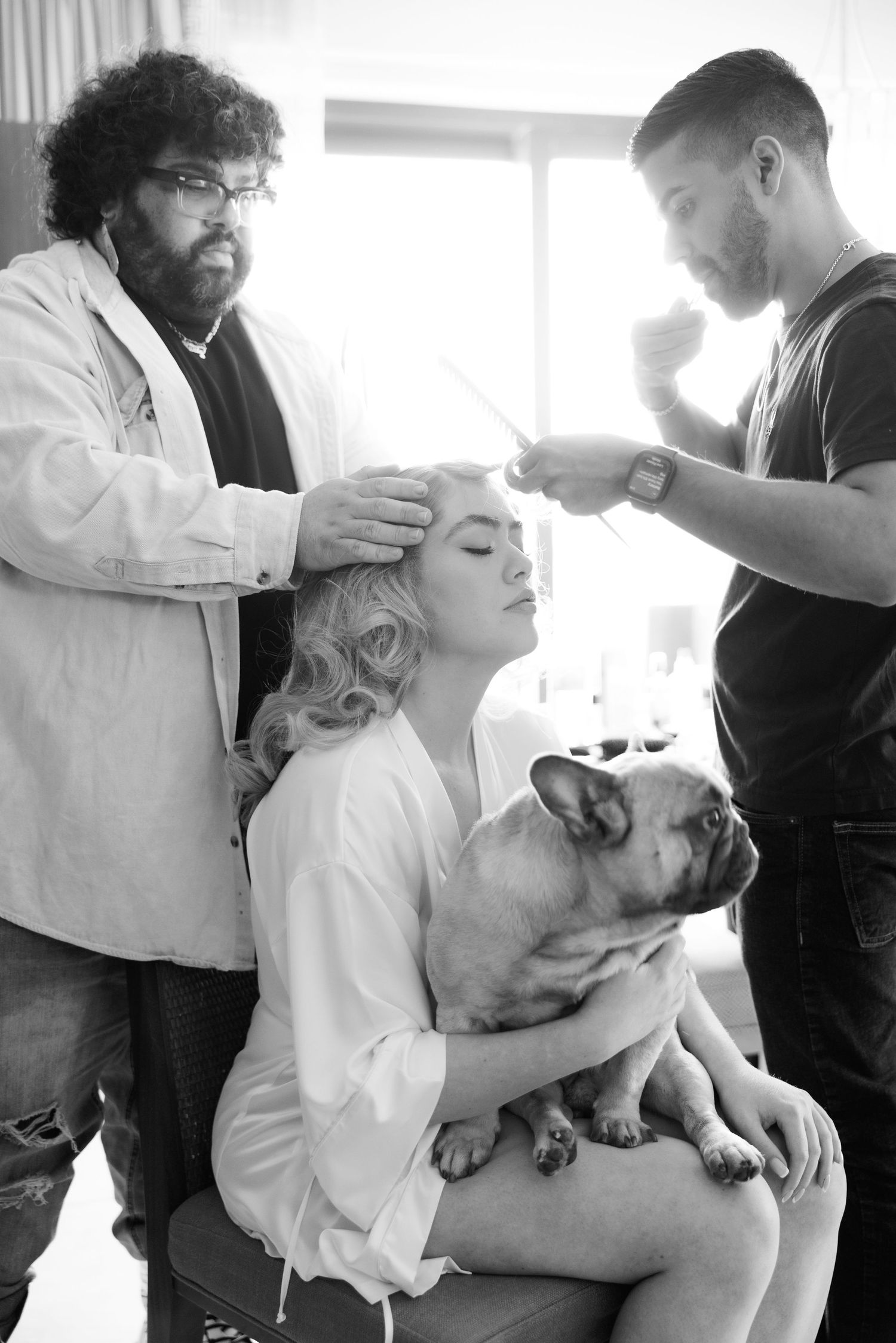 Series of intimate moments with a French Bulldog being held and cuddled during wedding preparations.