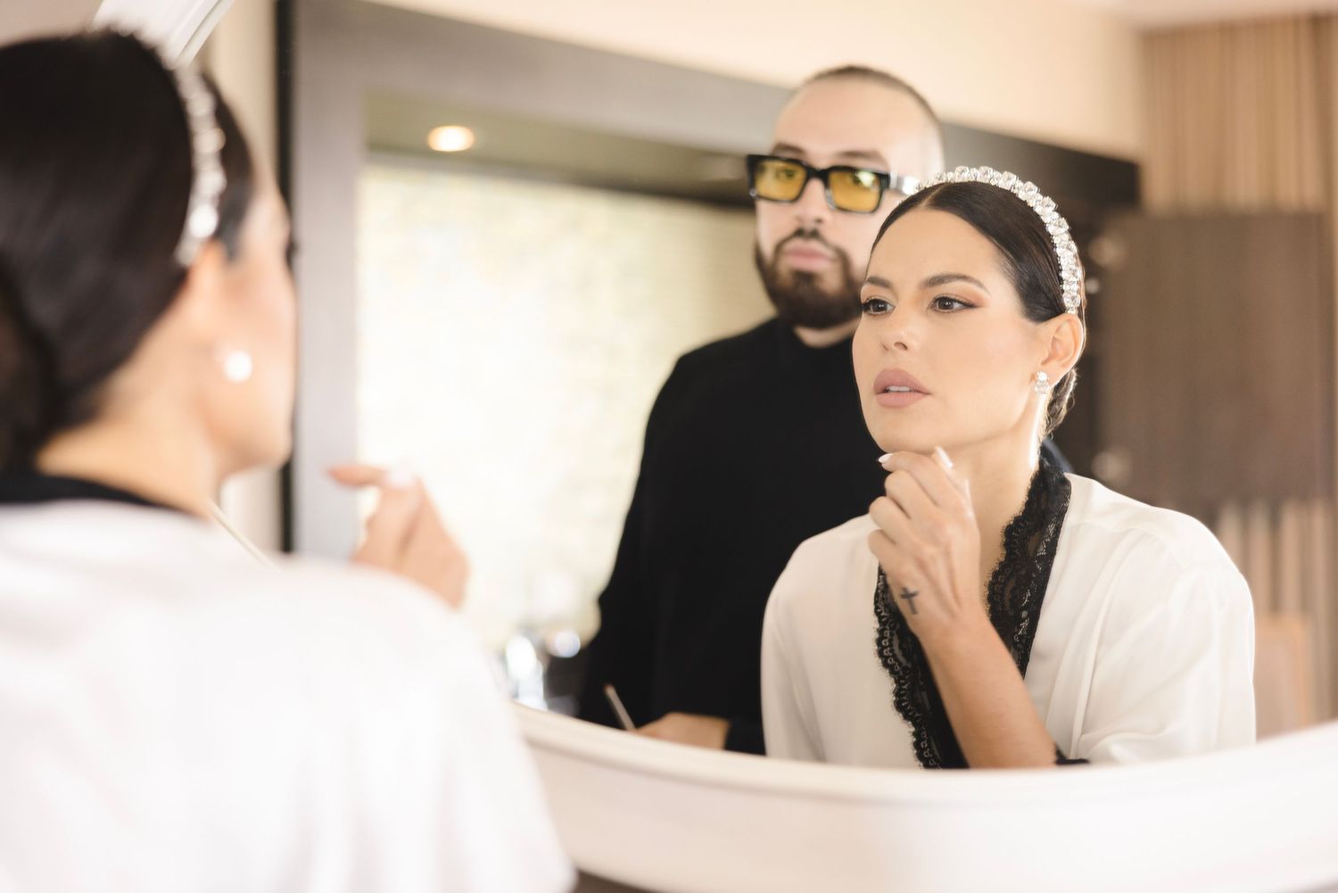 A montage of wedding preparation scenes showing details of bridal styling and makeup in a luxurious hotel room setting.