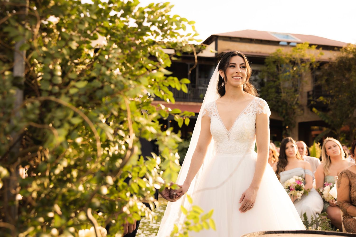 Sunlit garden wedding scene with natural foliage and elegant decor.