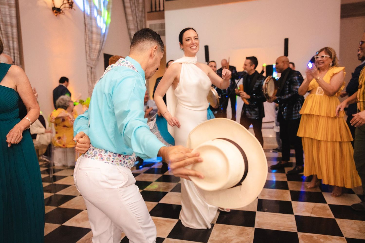 Wedding guests enjoying themselves on a black and white checkered dance floor at a reception party.