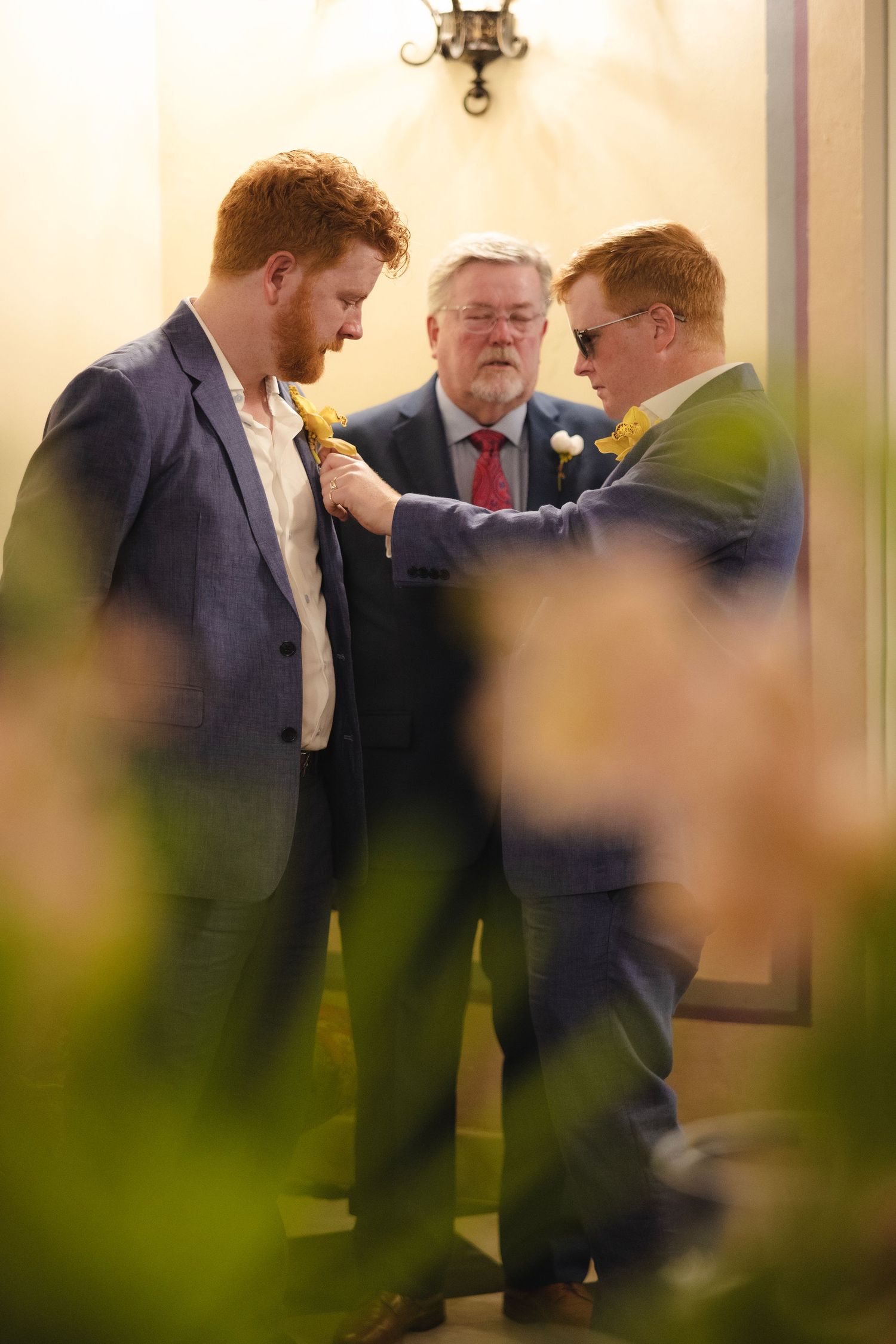 A group of formally dressed guests mingling indoors at an elegant event.