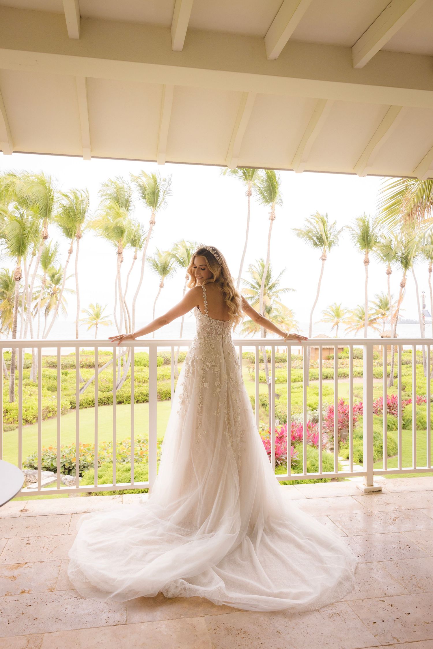 A series of wedding dress photos displayed on a bright outdoor porch with tropical palm trees and flowers in background.