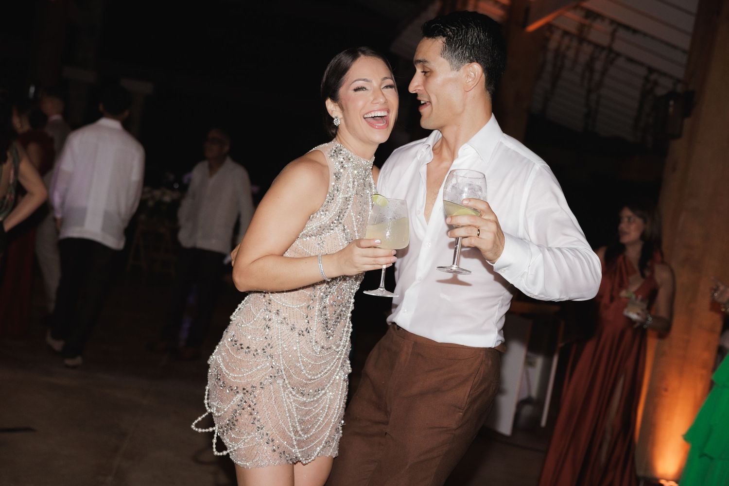 Couples dancing together at a formal event with elegant attire and ambient lighting.