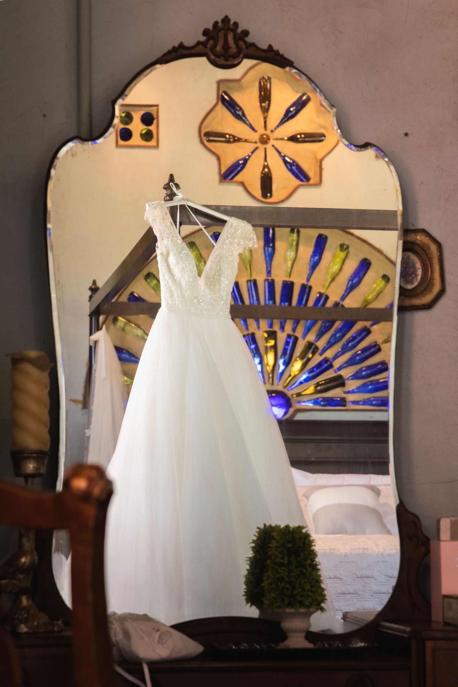 Five sequential photos show a white wedding dress displayed against an ornate wall with decorative blue sunburst patterns.
