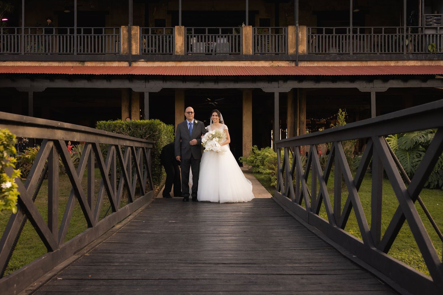 Wedding ceremony setup on wooden bridge walkway at sunset.