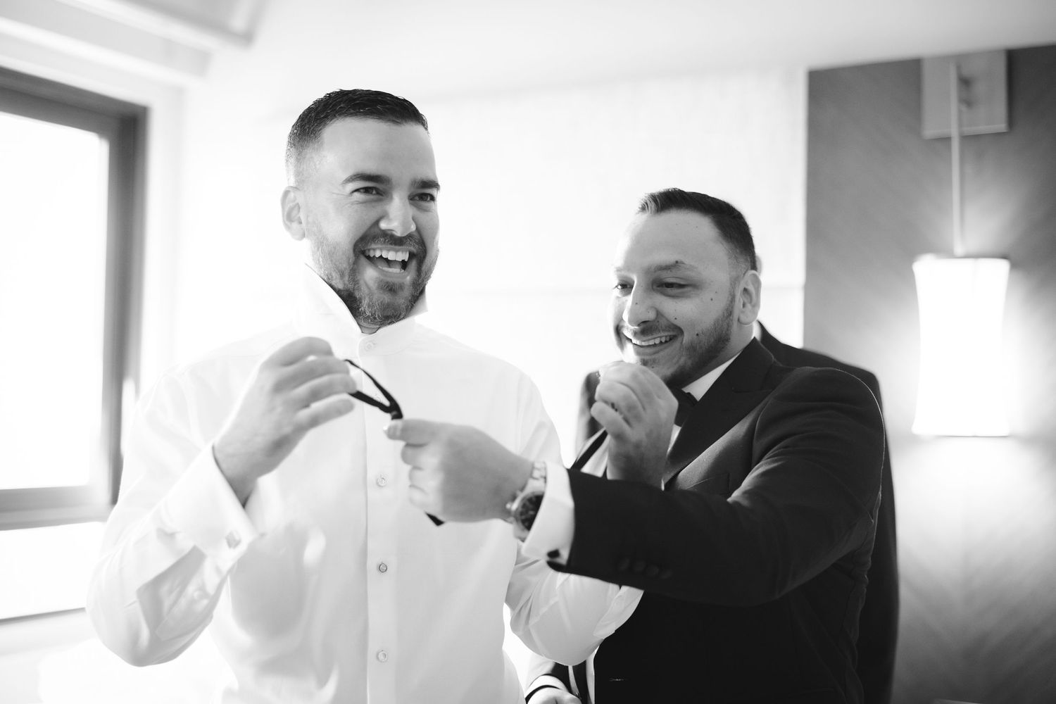 Black and white series of candid expressions showing laughter and joy in an indoor setting.