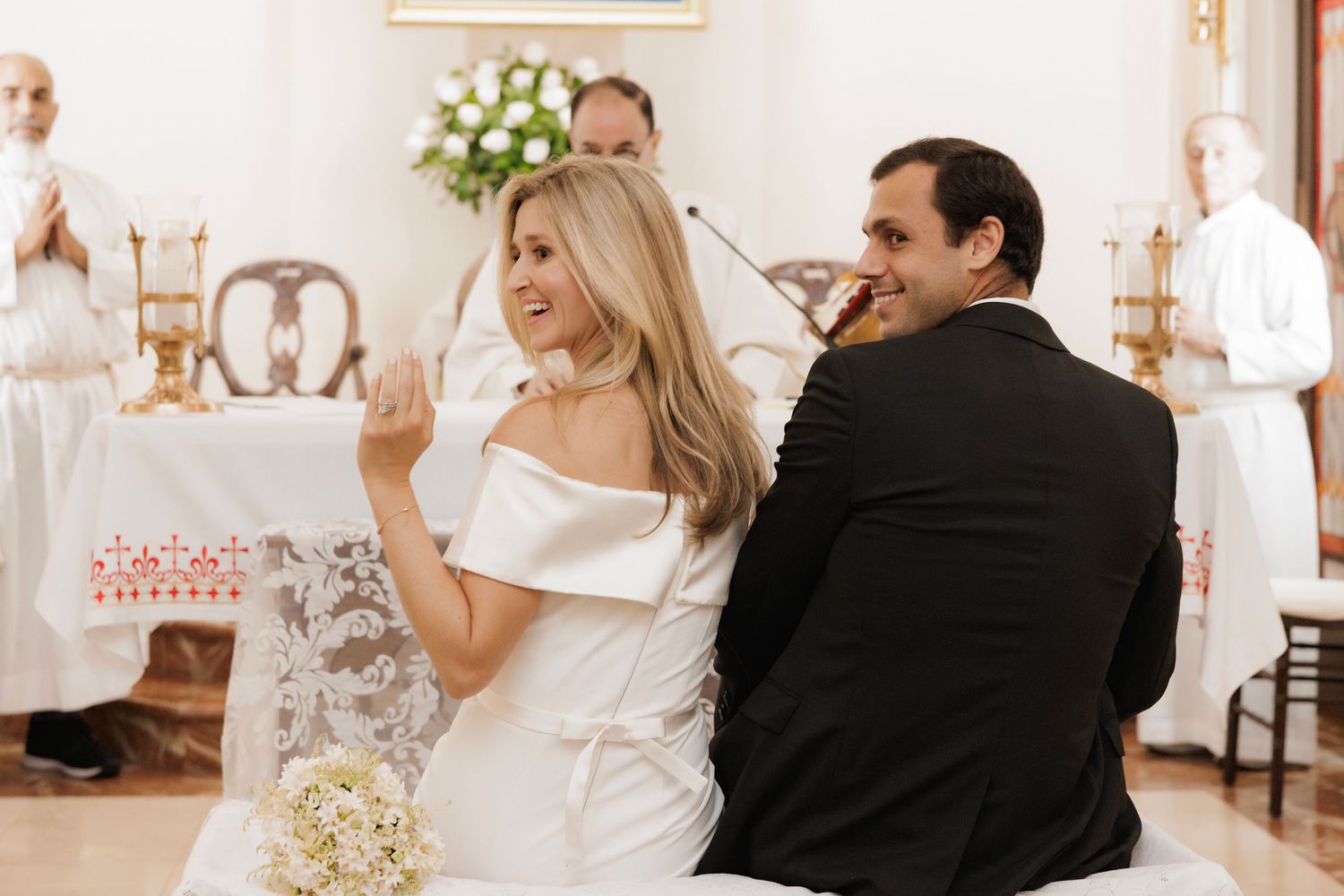 Joyful moments captured during an elegant wedding reception with white floral arrangements and formal attire.