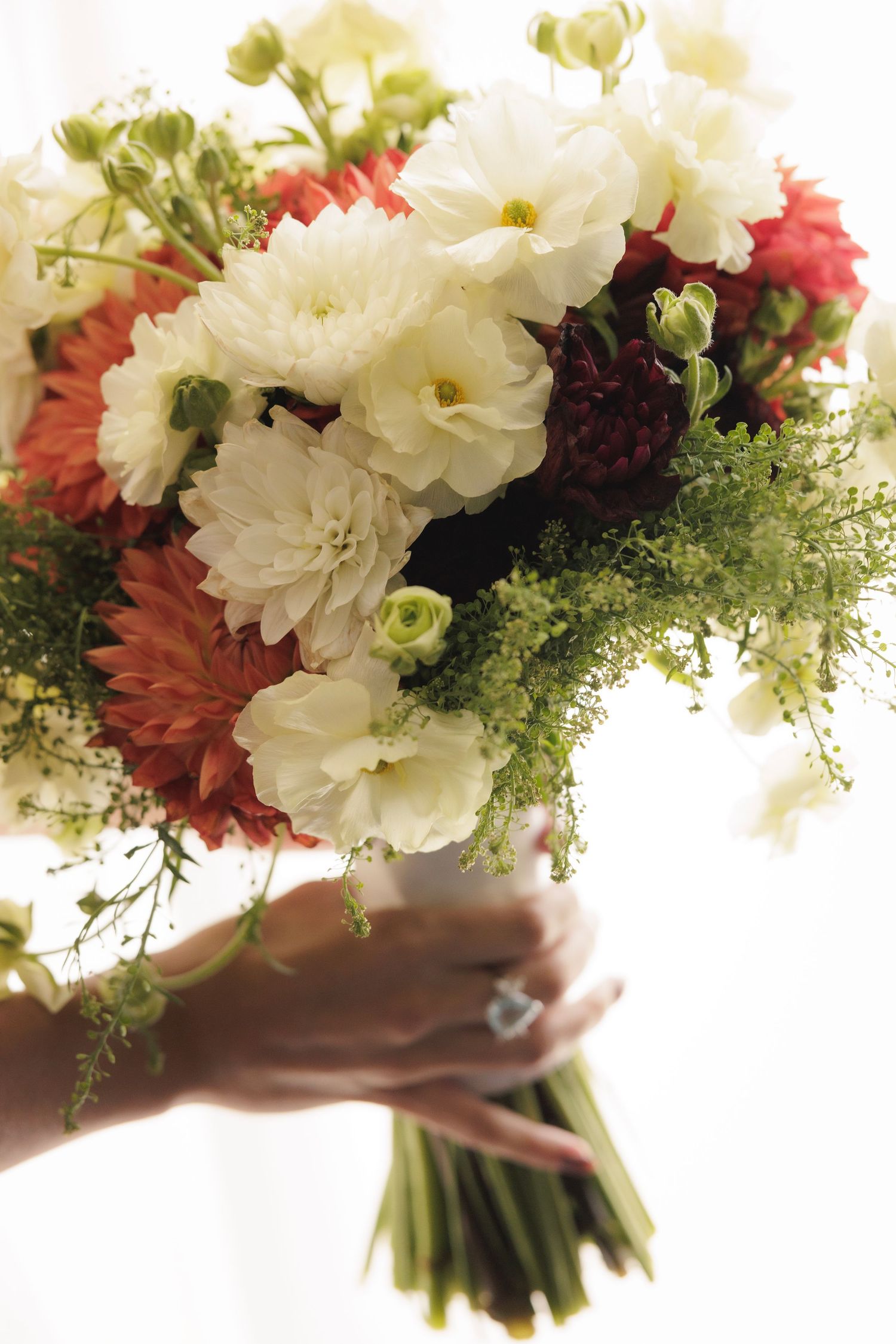 Beautiful bridal bouquet with white and coral flowers mixed with delicate greenery.