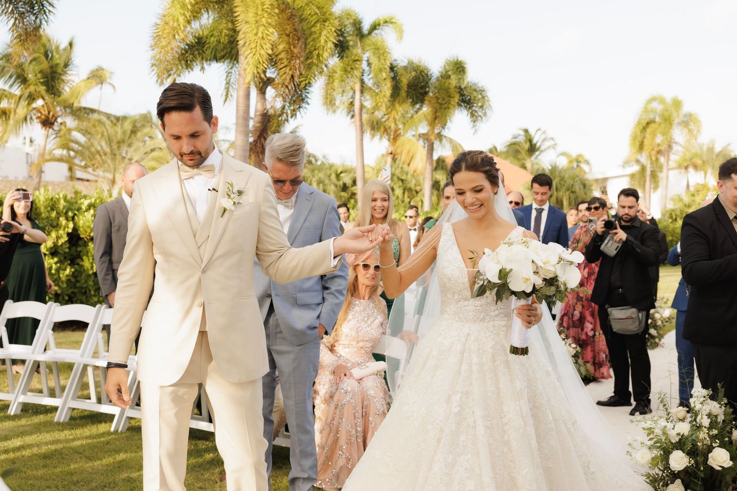 Row of wedding photographs showing a tropical beach ceremony and reception with palm trees and elegant decor.
