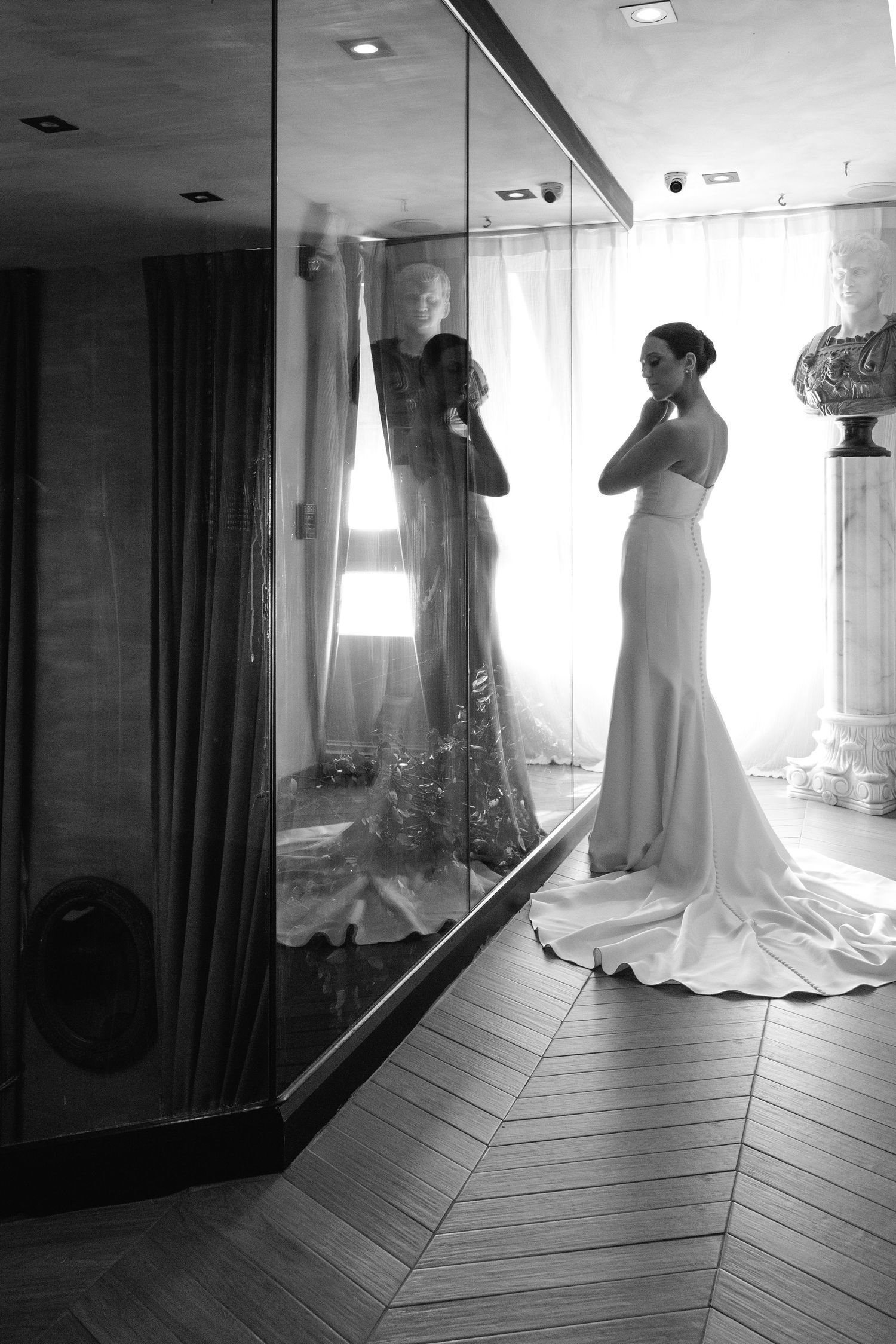 Multiple reflective black and white shots of a wedding dress in a mirrored dressing room.
