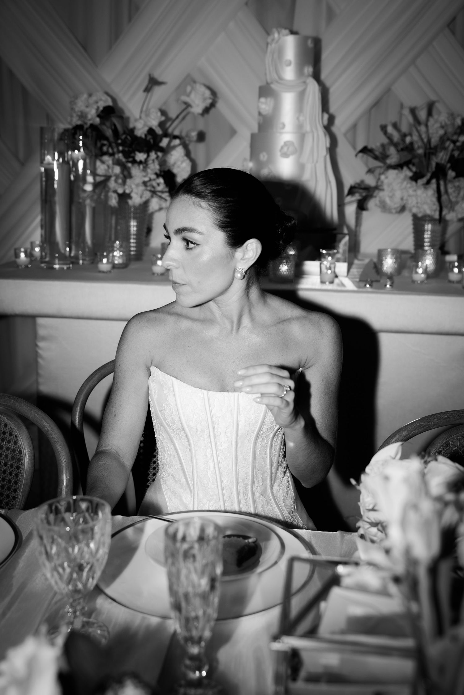 Black and white reception photos show a bride in a strapless gown seated at a dining table.