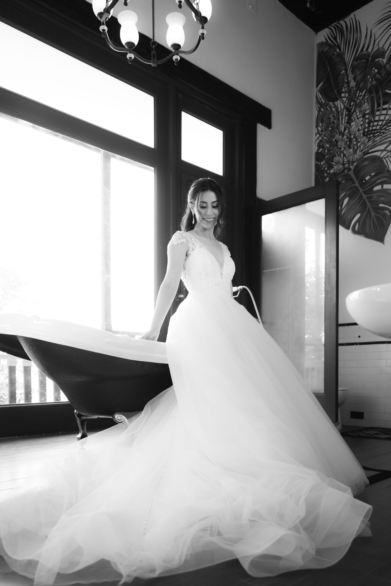A series of black and white photos showing a flowing white wedding gown as it gracefully twirls in dramatic lighting.
