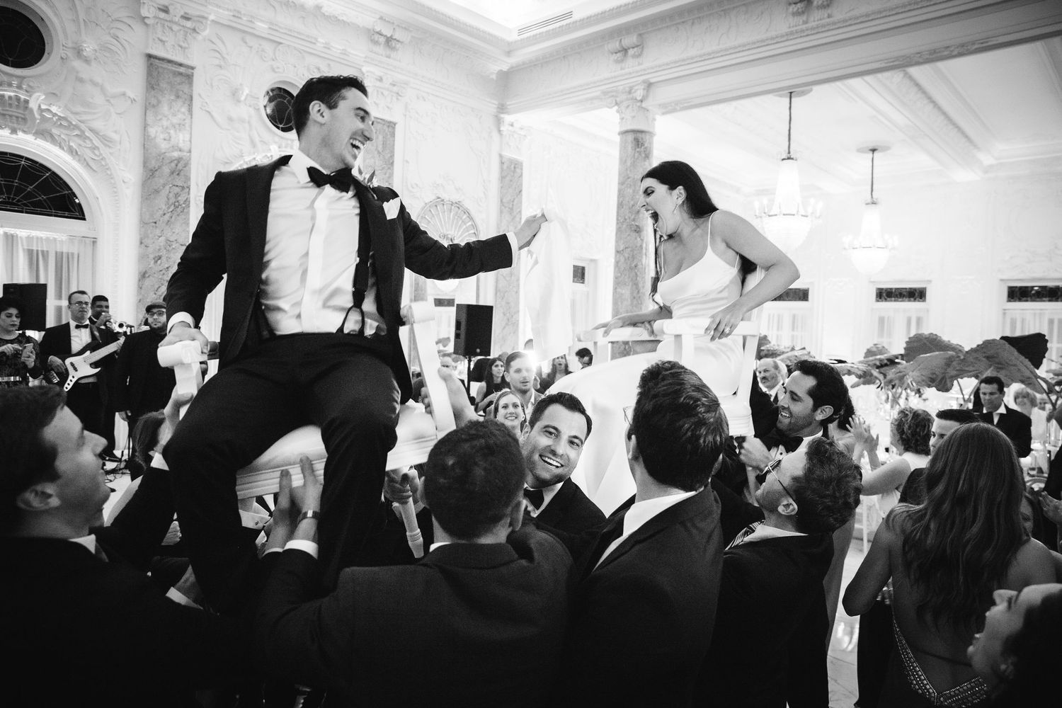 Black and white photos showing celebration moments during a lively wedding reception at an elegant indoor venue.