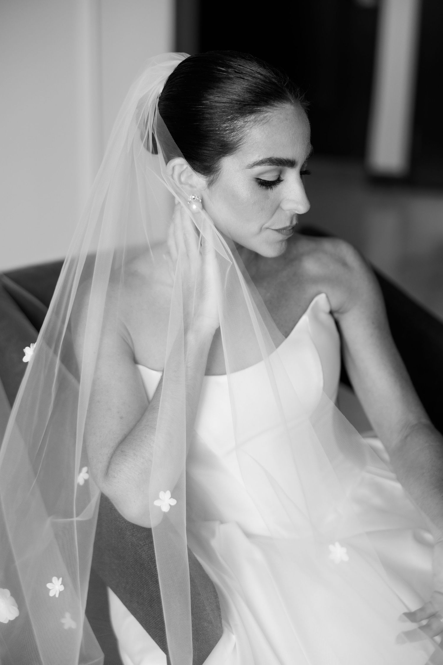 A delicate veil with floral appliques drapes elegantly over a bride in a white gown.