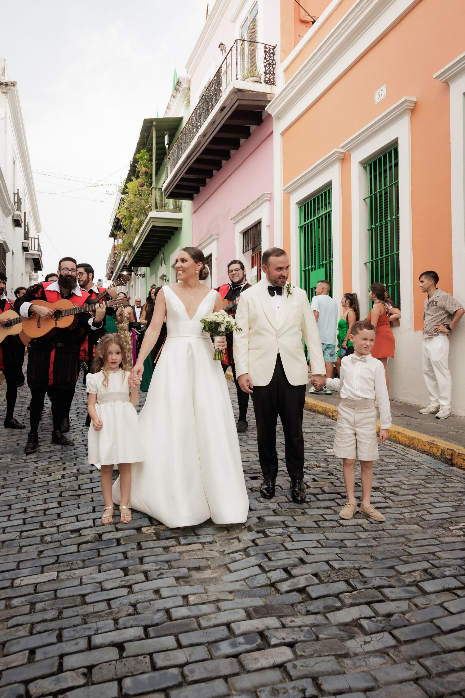 Wedding celebration on a charming cobblestone street lined with colorful colonial buildings.