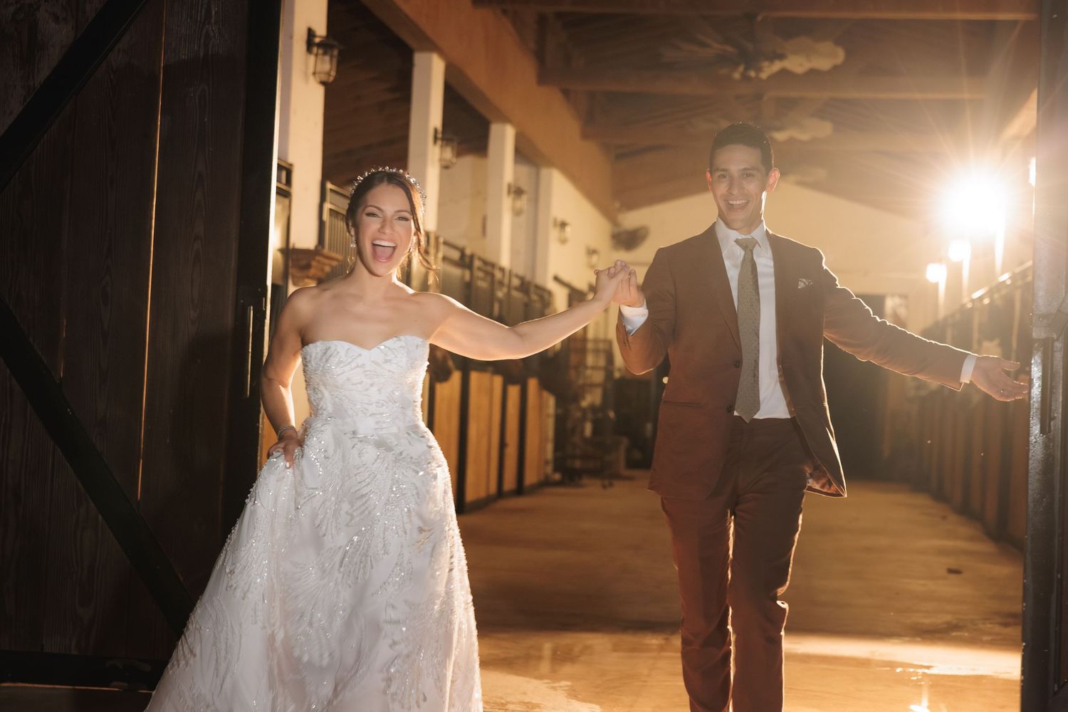 Couple in formal attire dancing together in a warmly lit outdoor space.