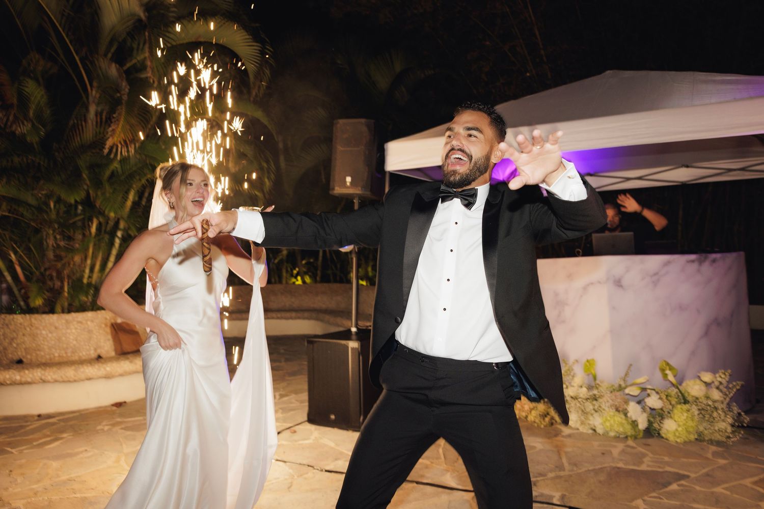 A series of images showing joyful dance moves at a wedding reception with sparklers and dim lighting.