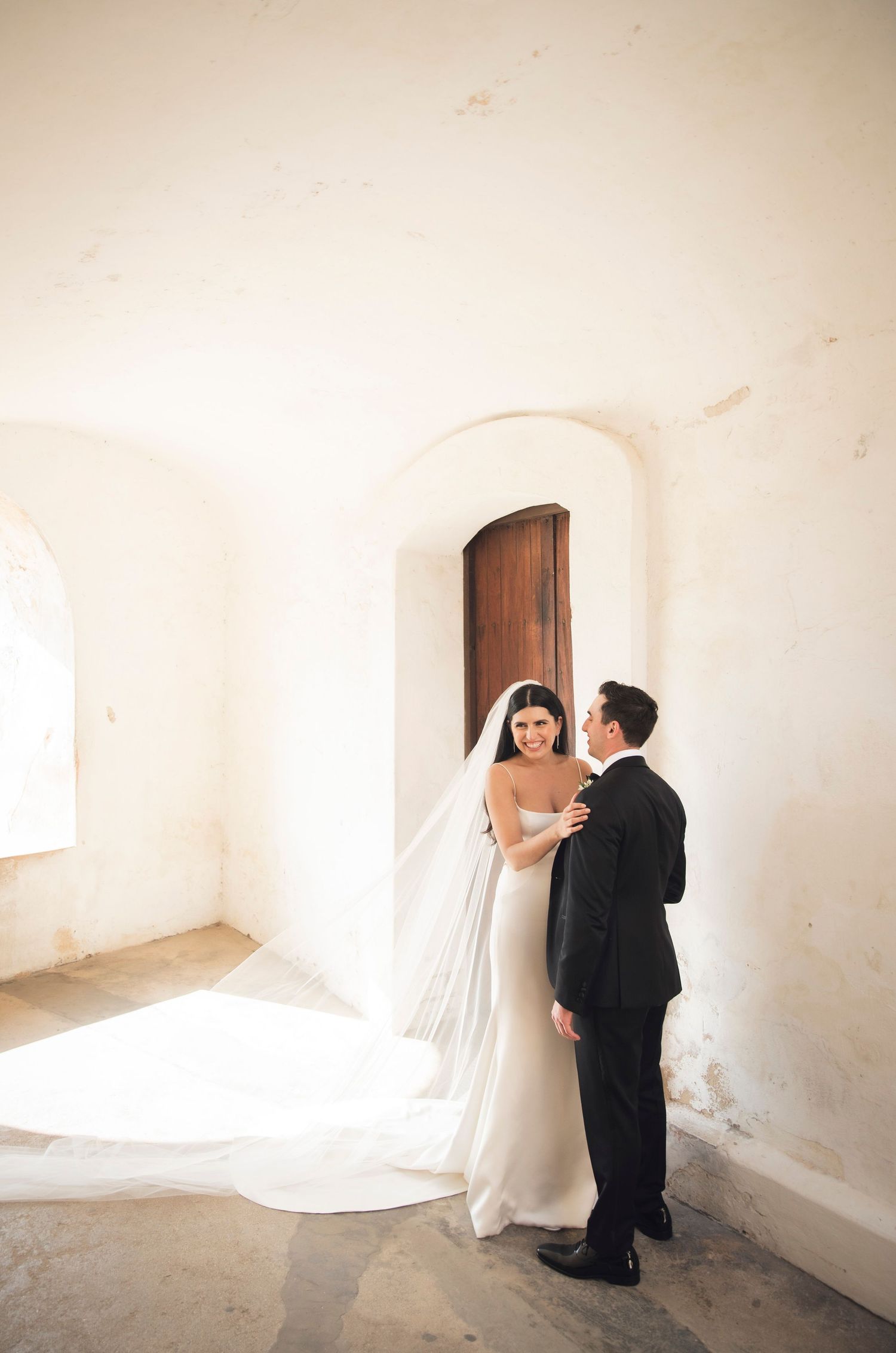 Romantic wedding photos captured in white stone archways and corridors.