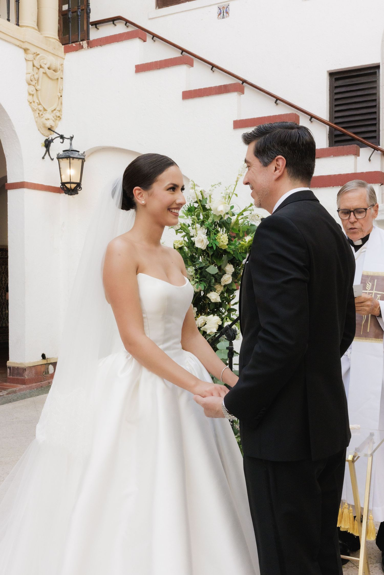 Wedding sequence showing bride and groom sharing intimate moments in front of white building with floral decor.