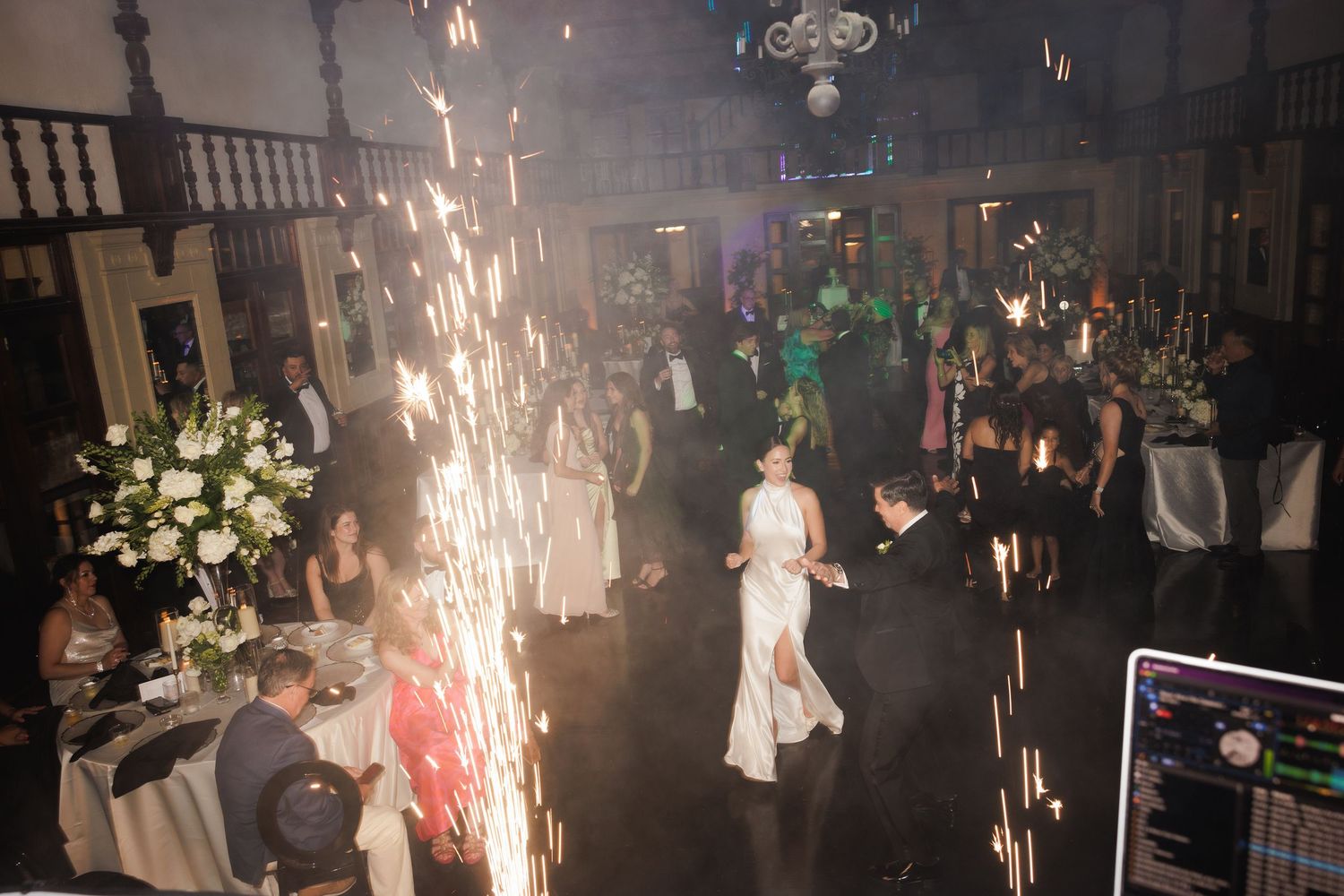 Sparklers create dramatic lighting effects at a dimly lit indoor celebration or party venue.