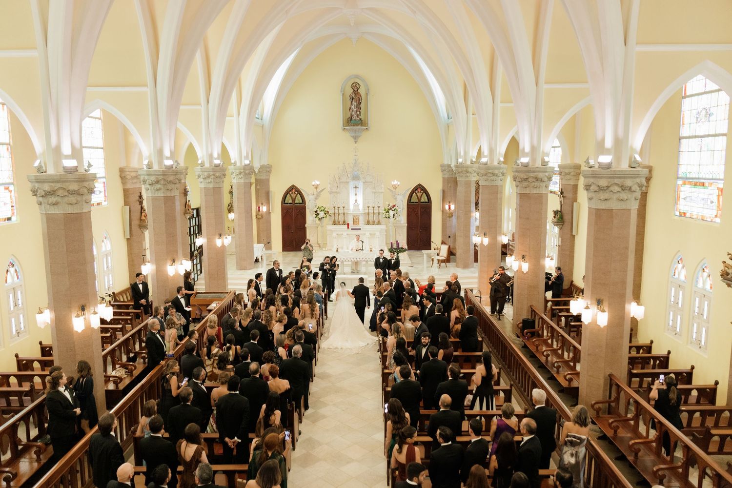 Traditional church wedding ceremony with guests seated in ornate sanctuary.