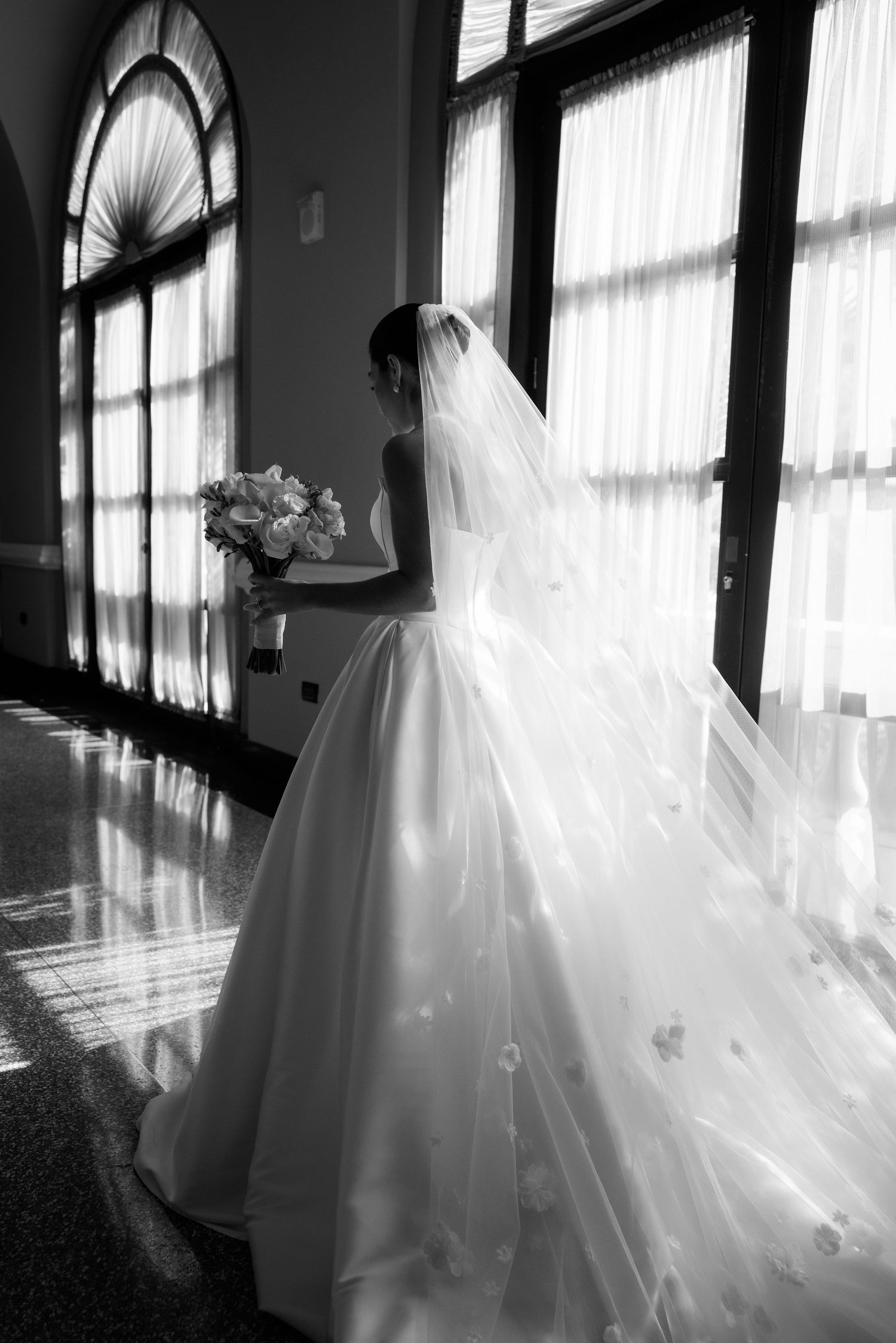 A series of black and white photos showing a flowing white wedding dress near sunlit windows.