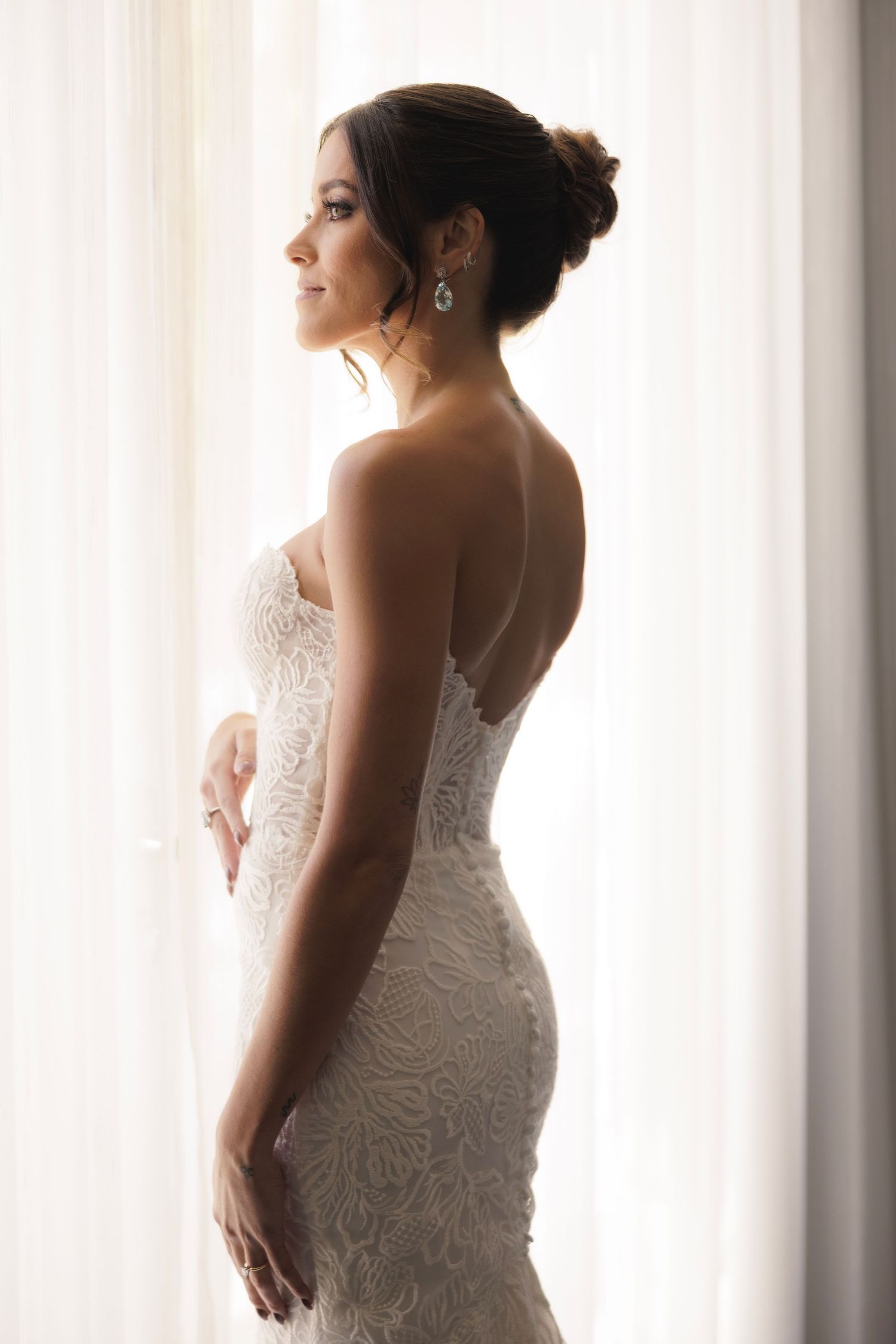 An elegant strapless wedding dress with delicate lace details photographed in dreamy natural light.