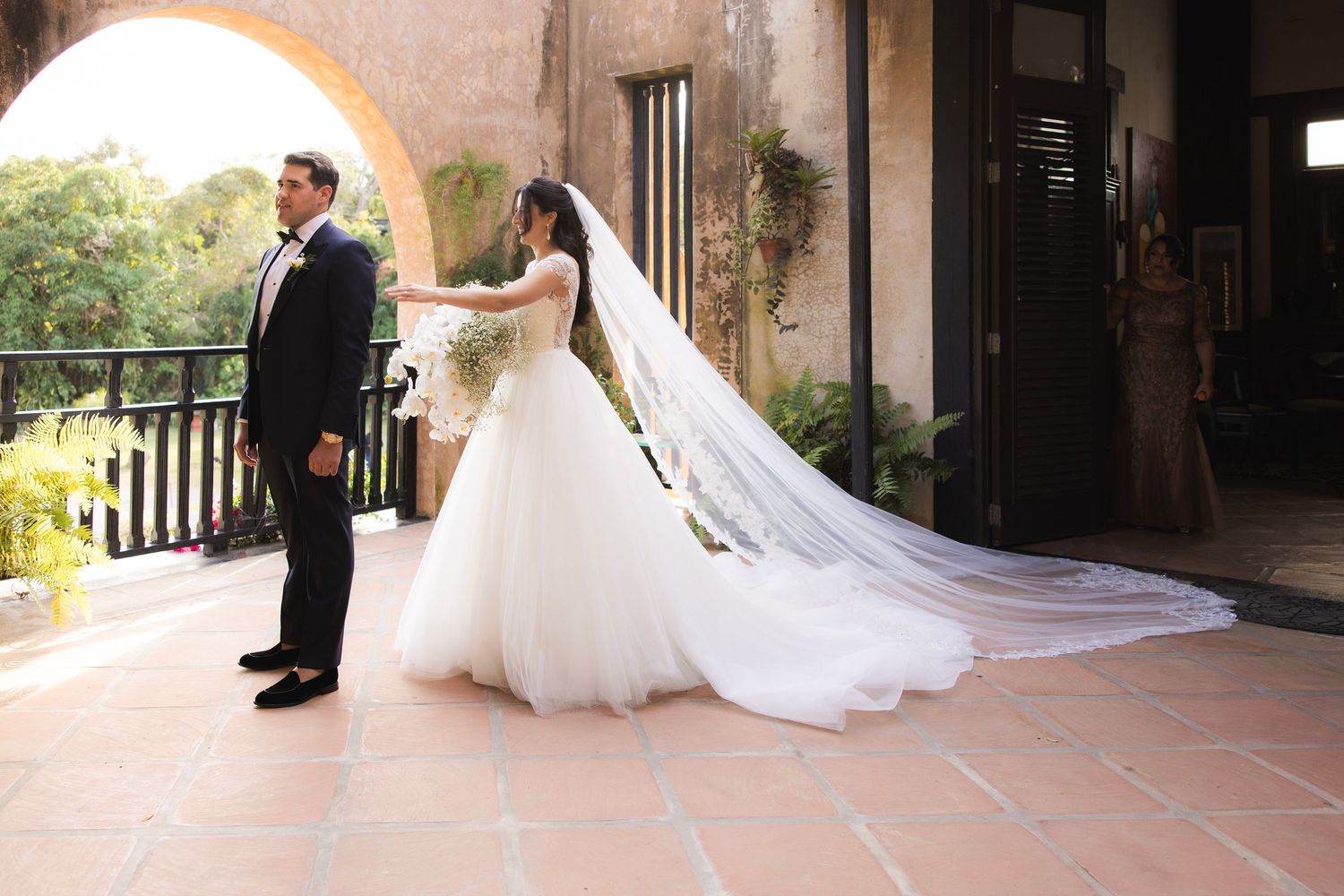 Romantic wedding photography sequence captures newlyweds walking together through stone archways at sunset.