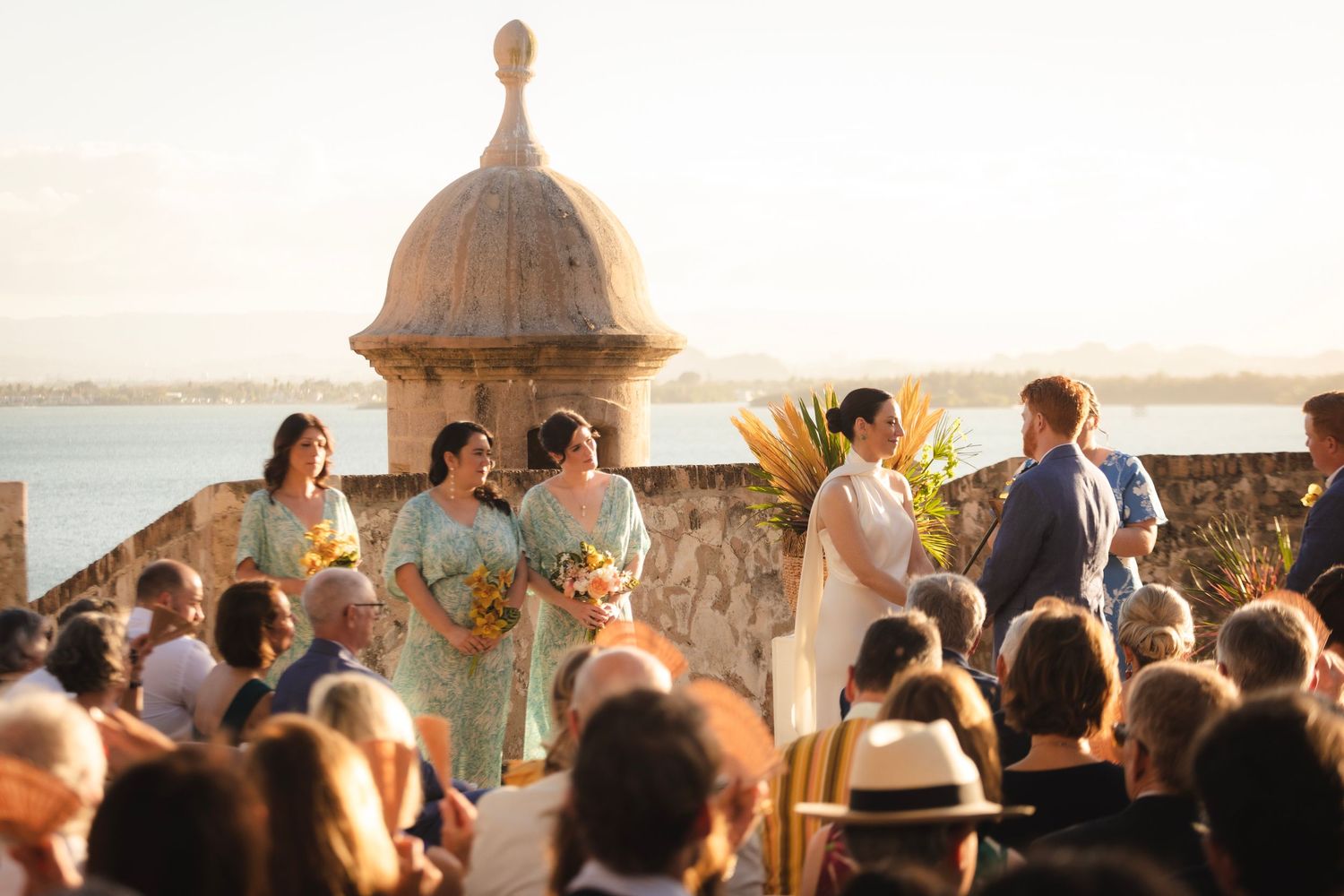 Sunset wedding ceremony gathering with guests watching from their seats.