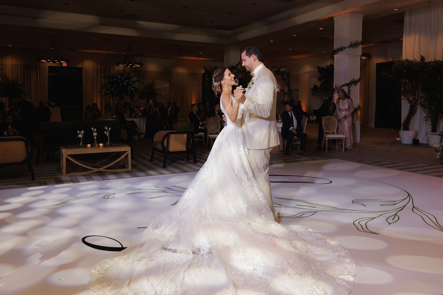 A bride in a flowing white dress creates foggy swirls of movement as she dances on a ballroom floor.