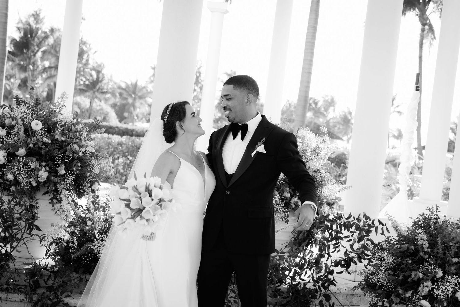 Black and white wedding photos displayed in sequence showing romantic moments on a porch with white columns.