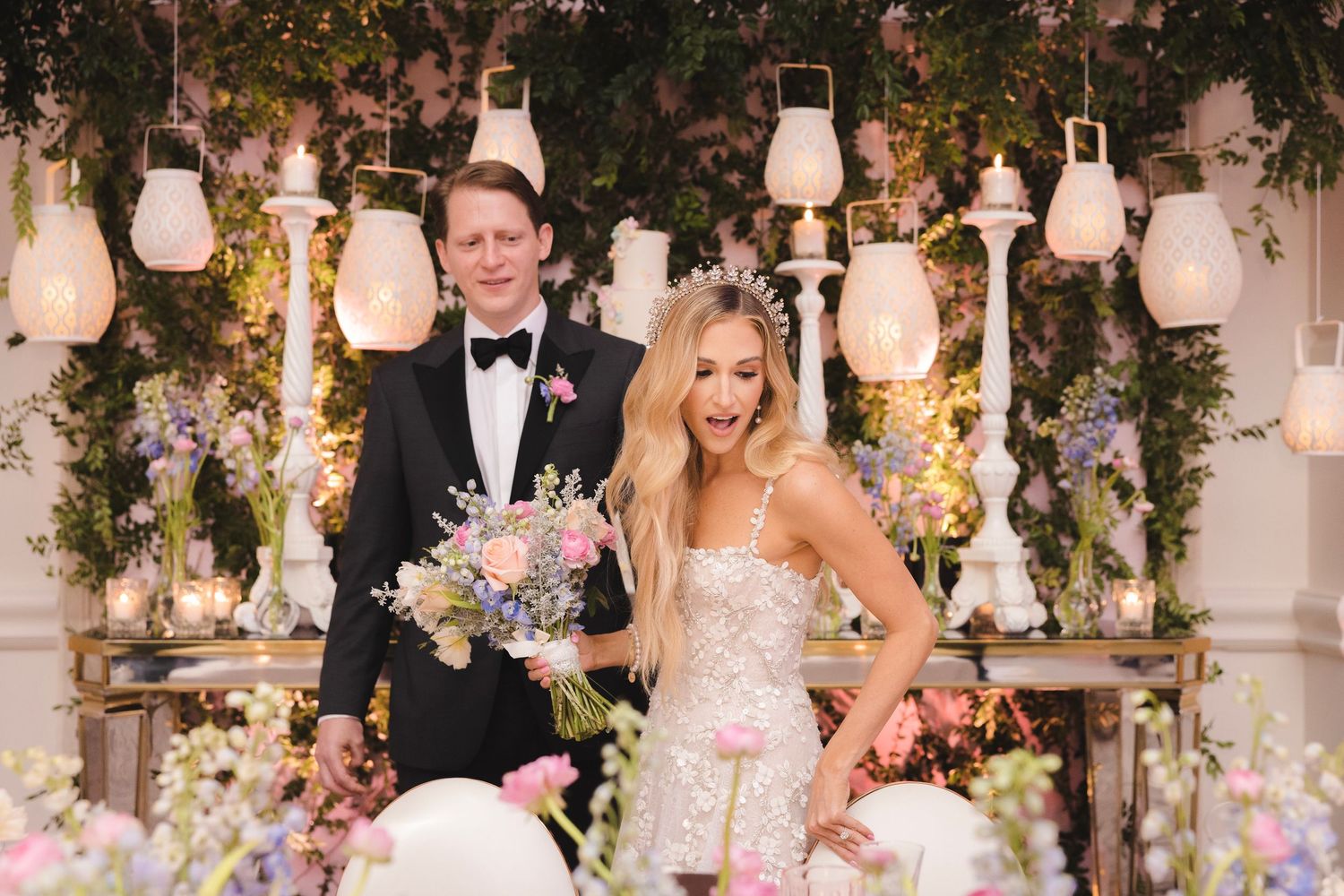 Elegant wedding reception venue with hanging lanterns, floral arrangements, and decorative elements creating a romantic atmosphere.