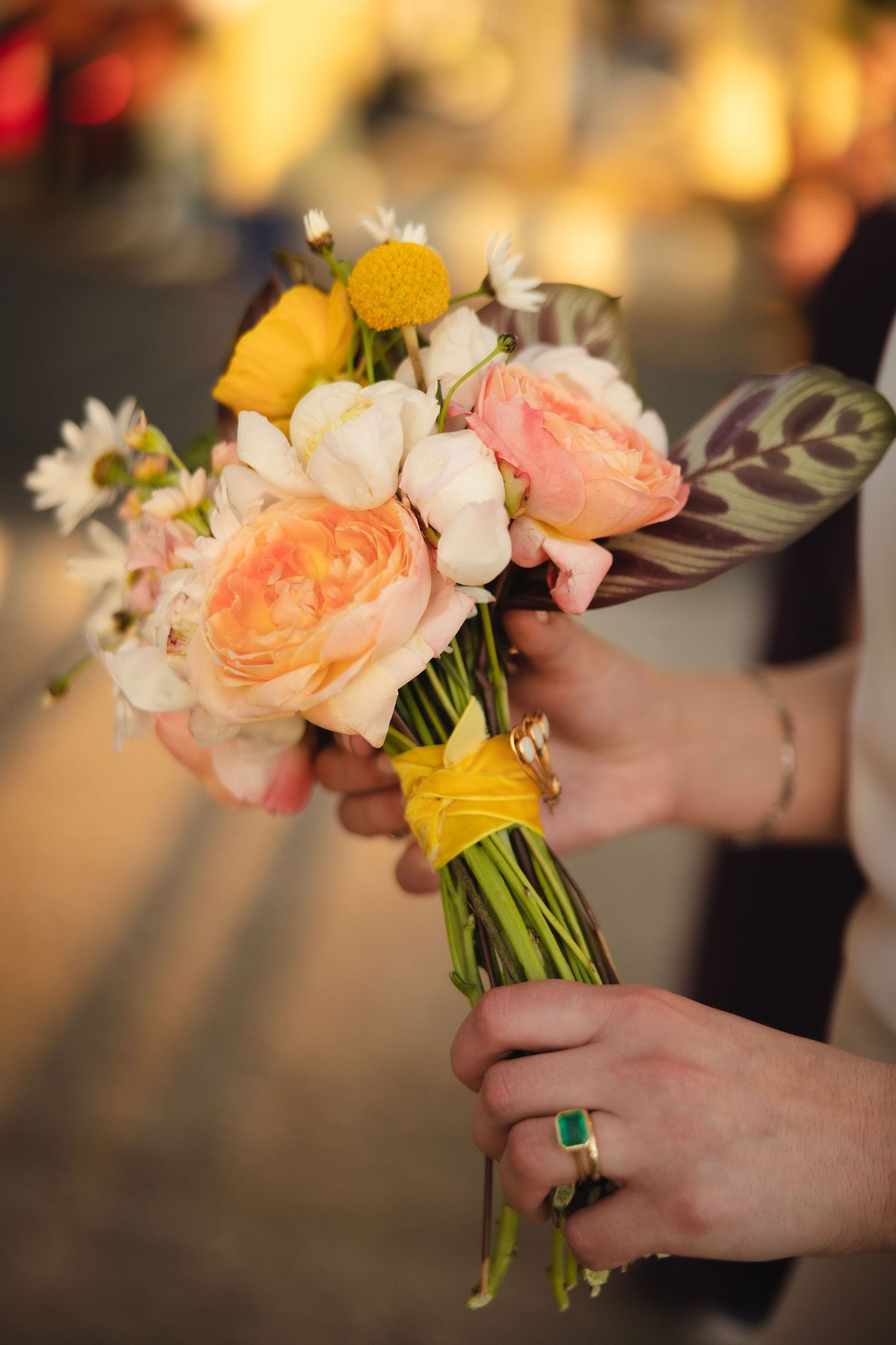 Close-up shots of peach and yellow bouquet flowers being held, showing delicate floral arrangement details.