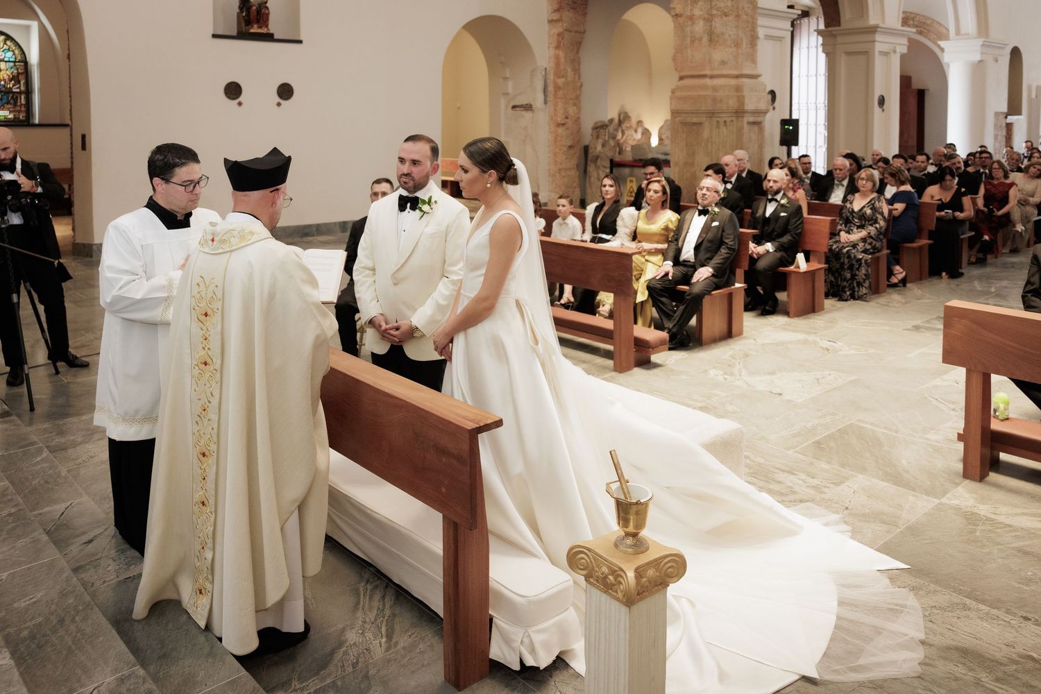 A series of photos showing a Catholic church ceremony with clergy in white robes performing rituals at the altar.
