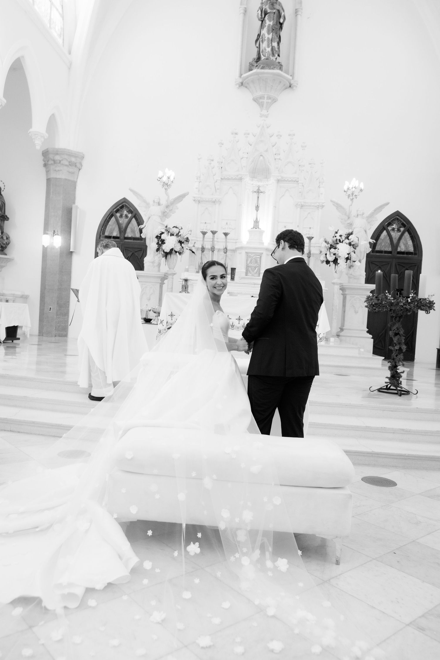 Black and white photo captures an intimate moment during a traditional church wedding ceremony.
