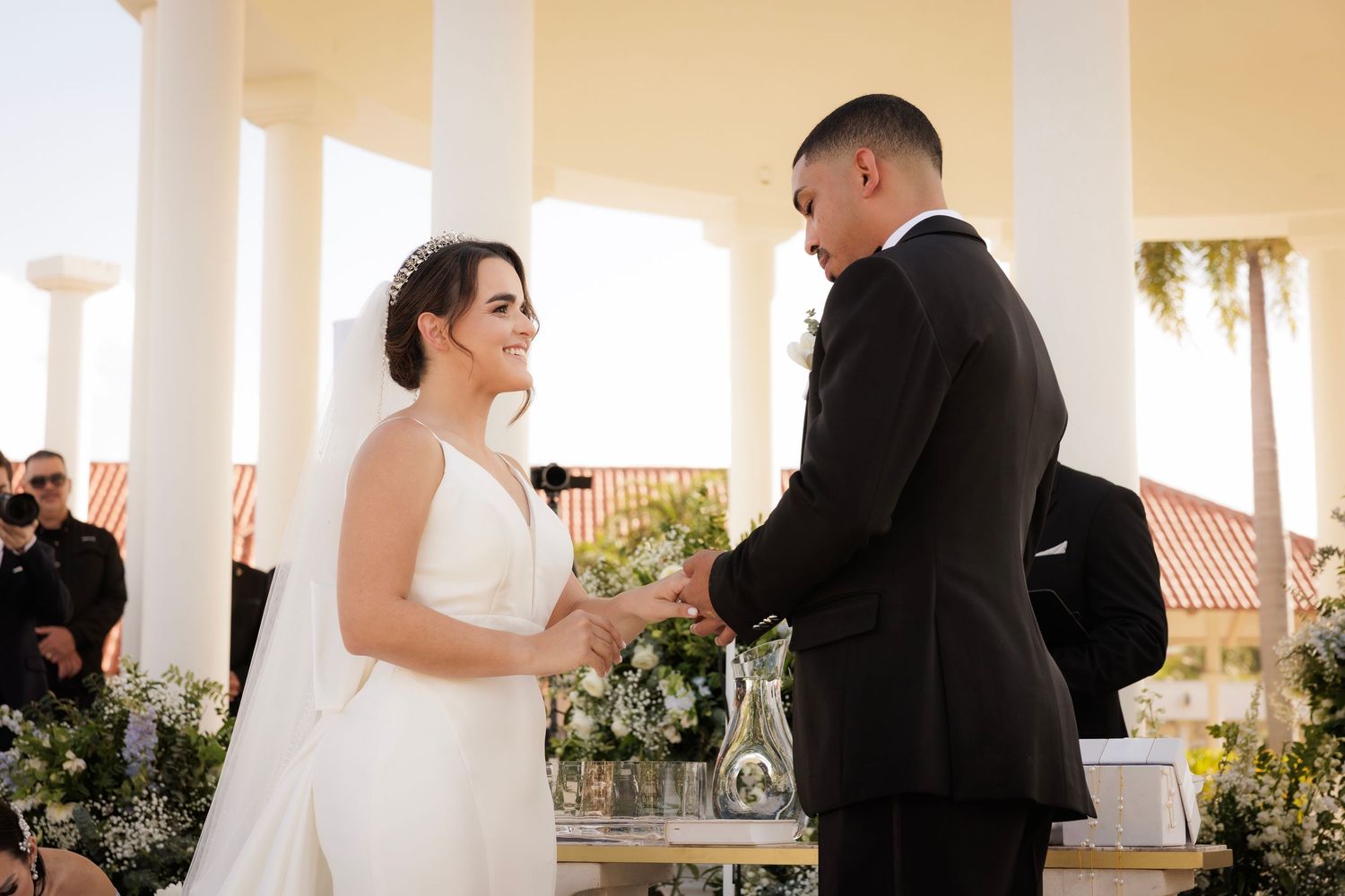 Newlywed couple shares romantic first dance together under warm lighting at outdoor wedding venue.
