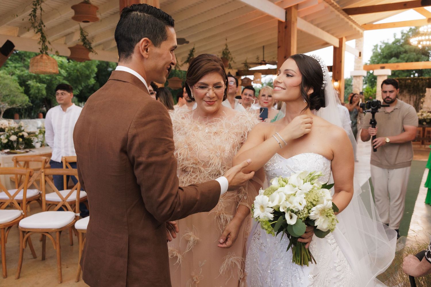 A joyful moment shared during an outdoor wedding ceremony with a beautiful floral backdrop and rustic decor.