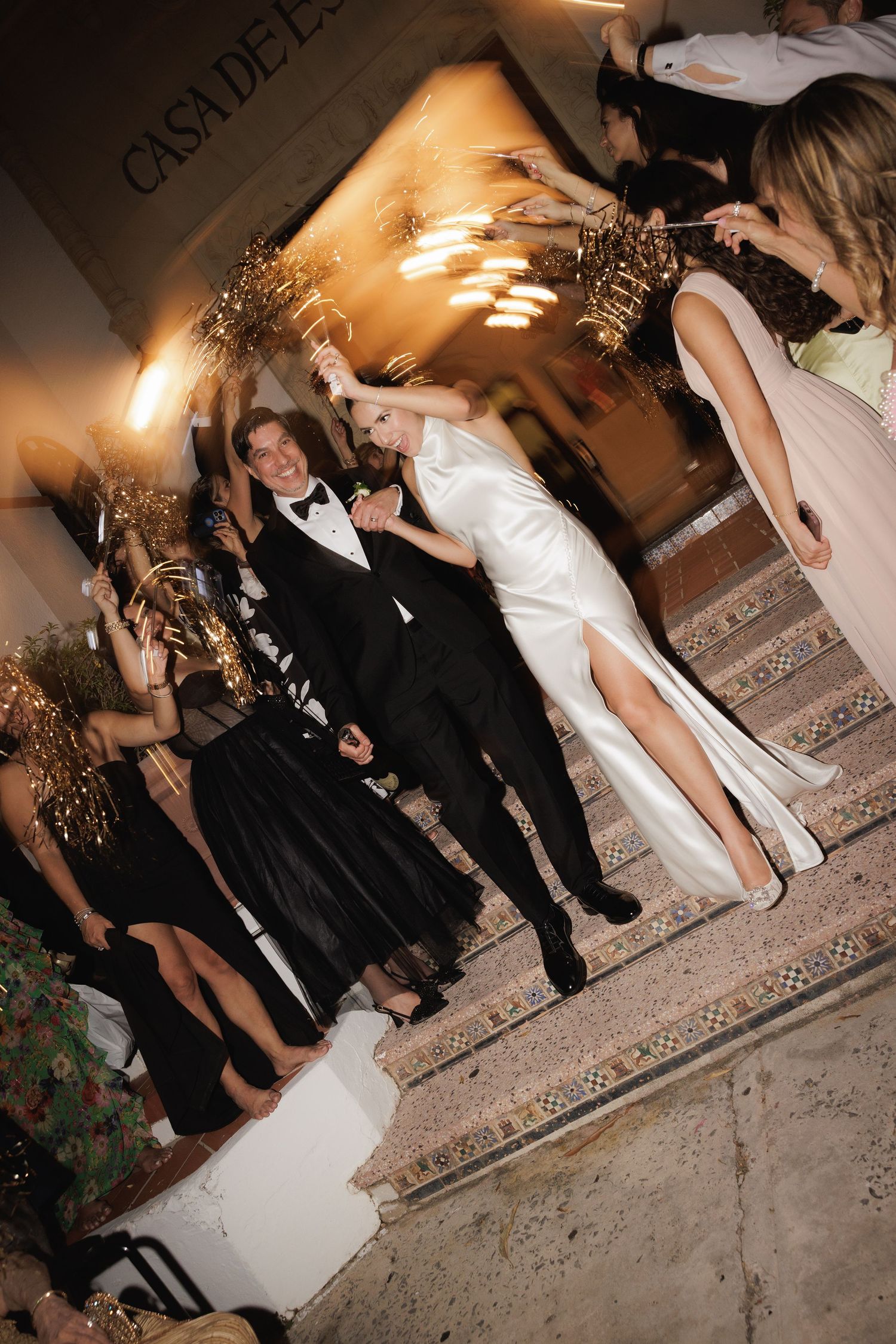 A festive wedding celebration with sparklers lighting up an evening reception entrance.