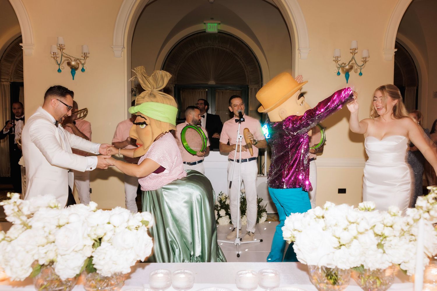 Panoramic view of a wedding reception hall with elegant decor and guests celebrating.