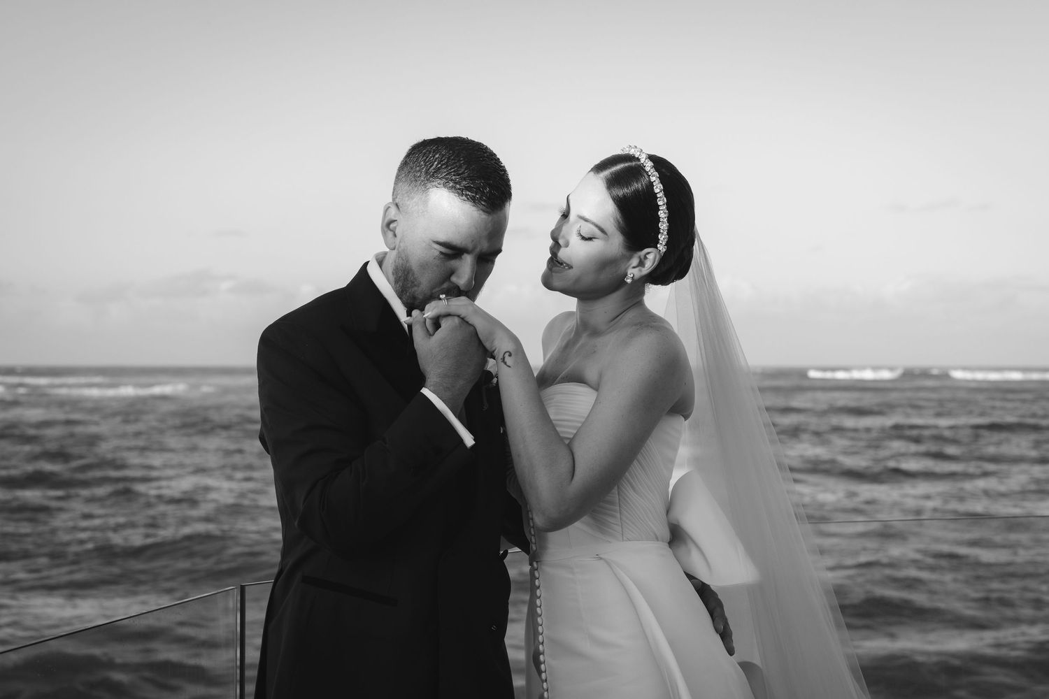 A romantic sequence of beach wedding photos showing a couple embracing by the ocean in black and white.