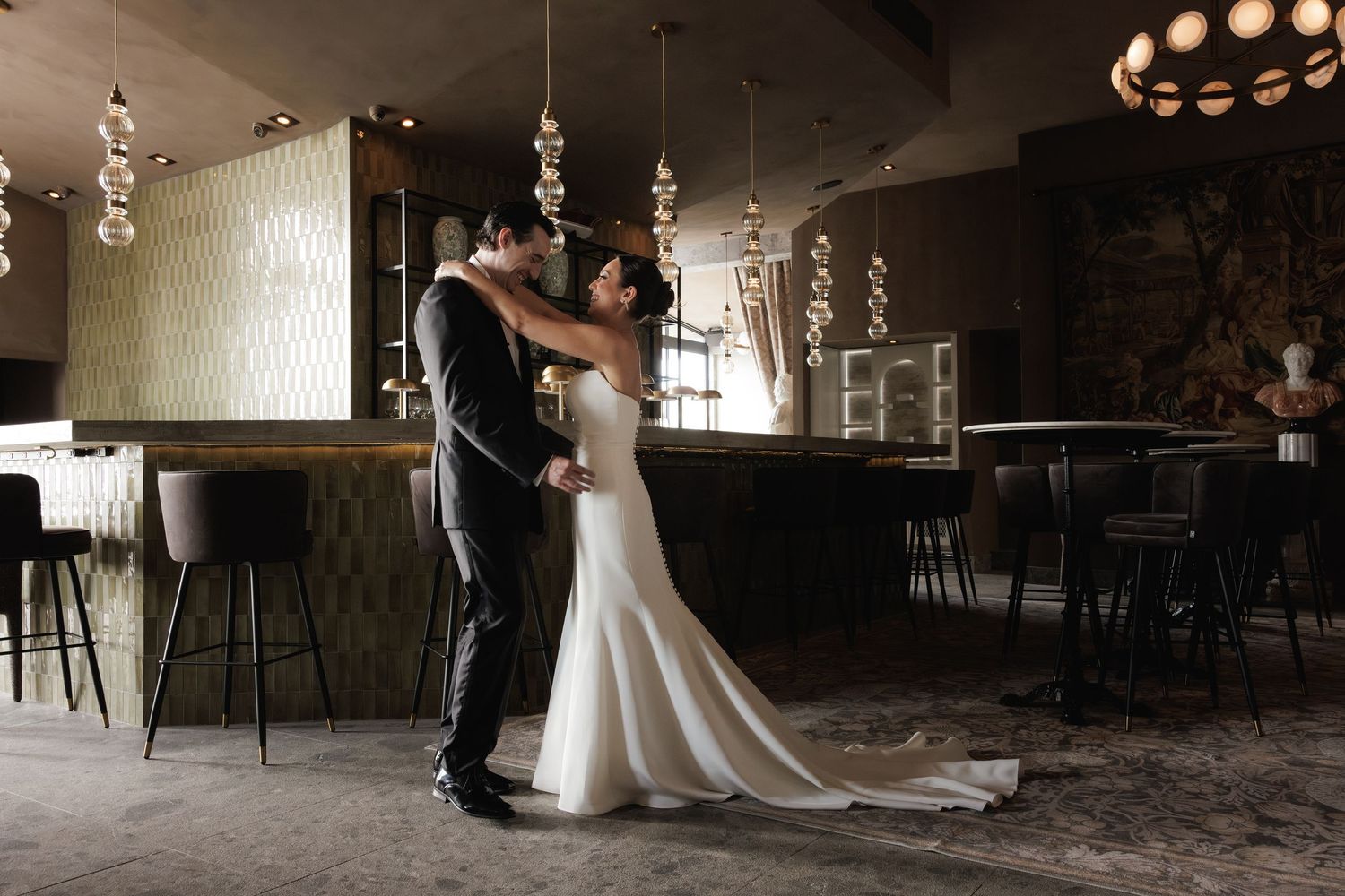 Five romantic couple dance photos in a dimly lit venue showcase elegant movement and formal attire in black and white.