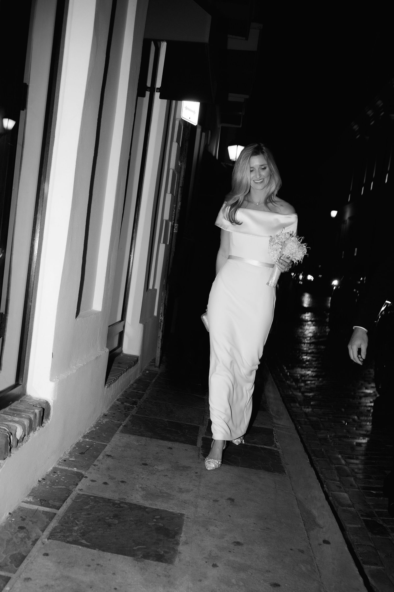 A series of four black and white images showing a figure in white clothing walking down a dark corridor at night.