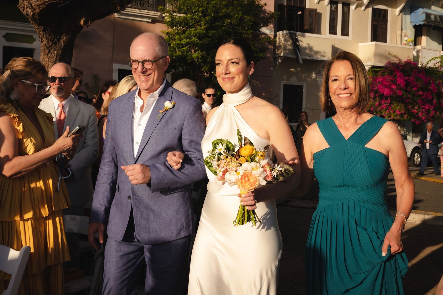 Wedding celebration with guests in navy suits and emerald green dresses at an elegant venue.