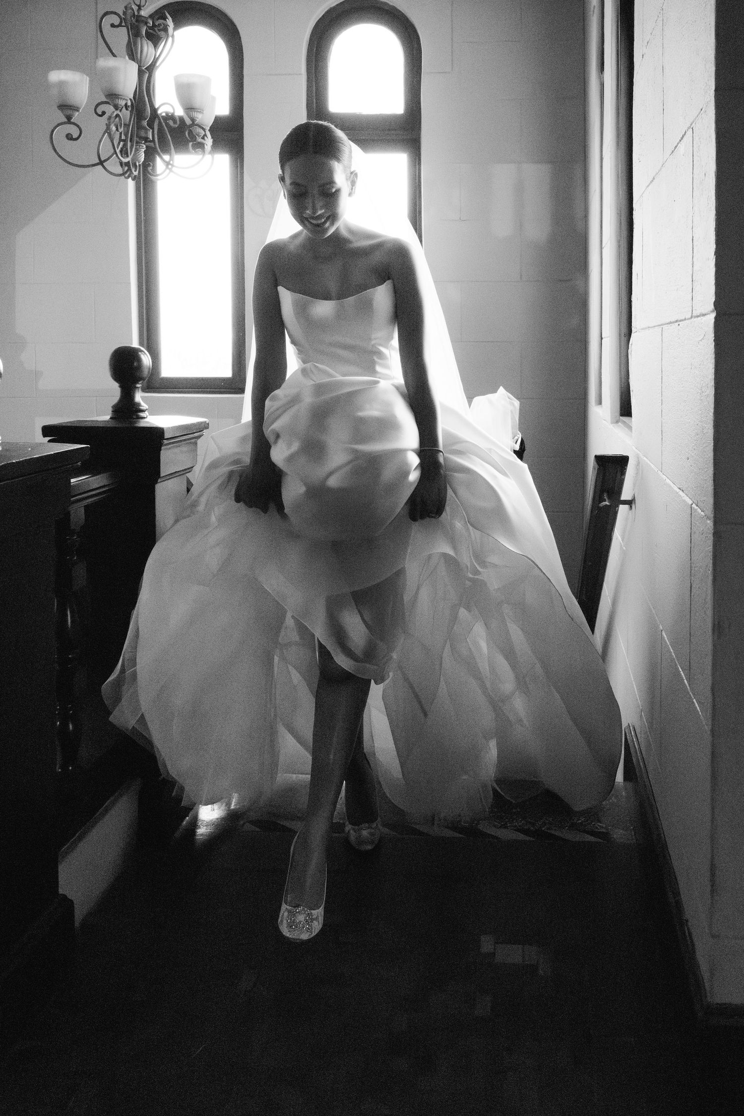 Artistic black and white photos showing movement of a flowing white dress in window light.