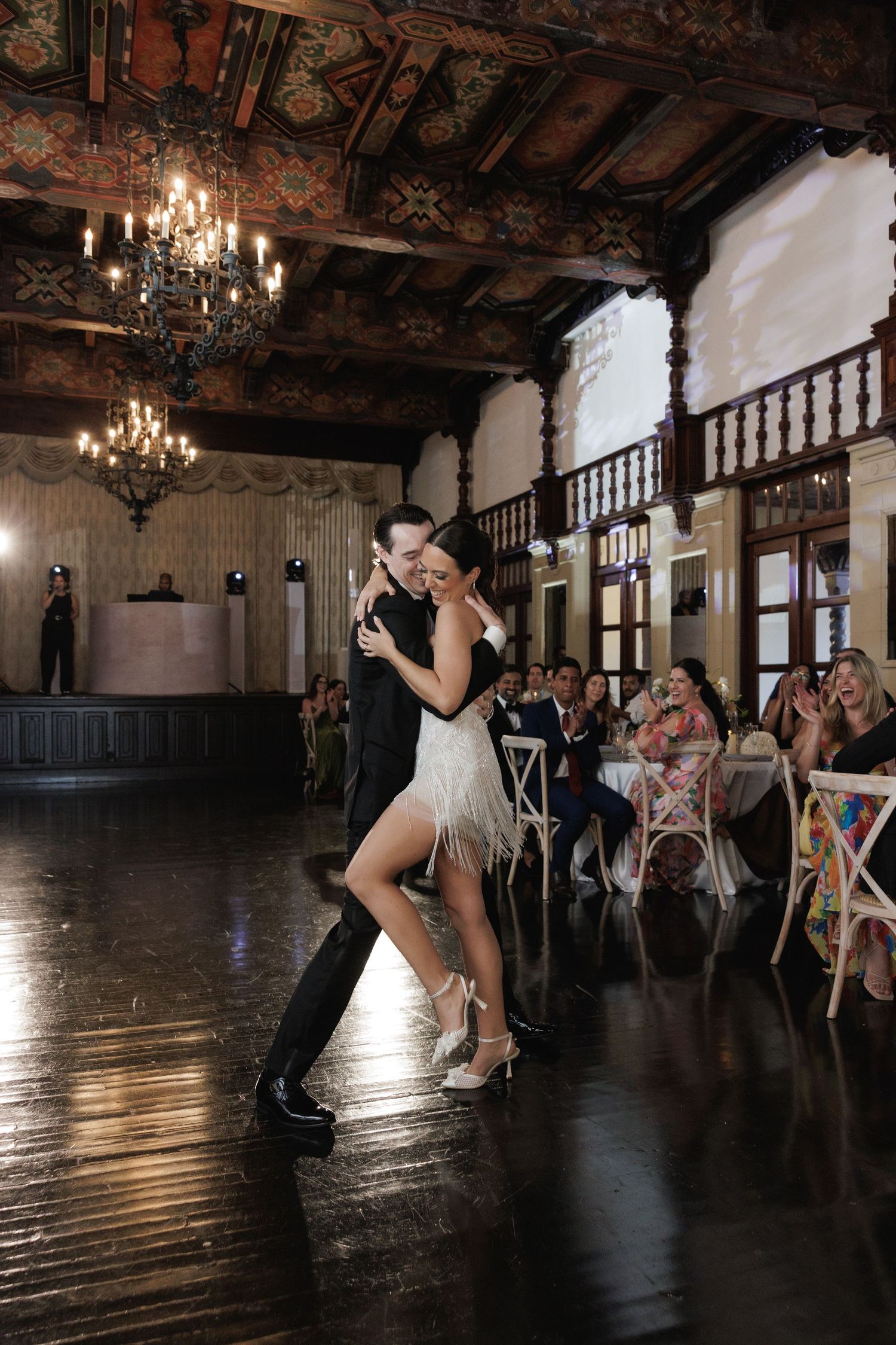 Romantic dance moves captured in a vintage ballroom setting with ornate details and chandelier lighting.