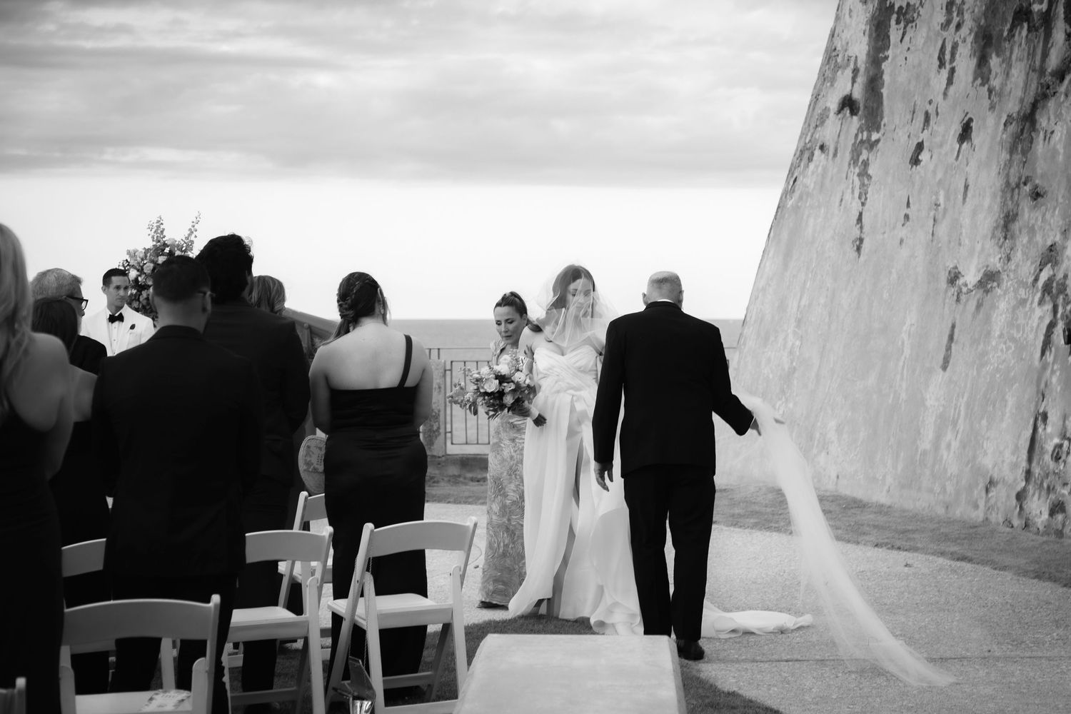 Black and white wedding ceremony photographs against stone walls.