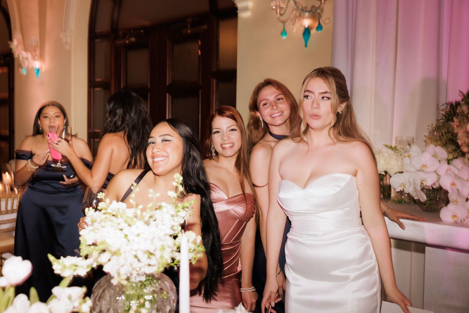 Wedding party guests dancing and celebrating together on the dance floor at an elegant reception venue.