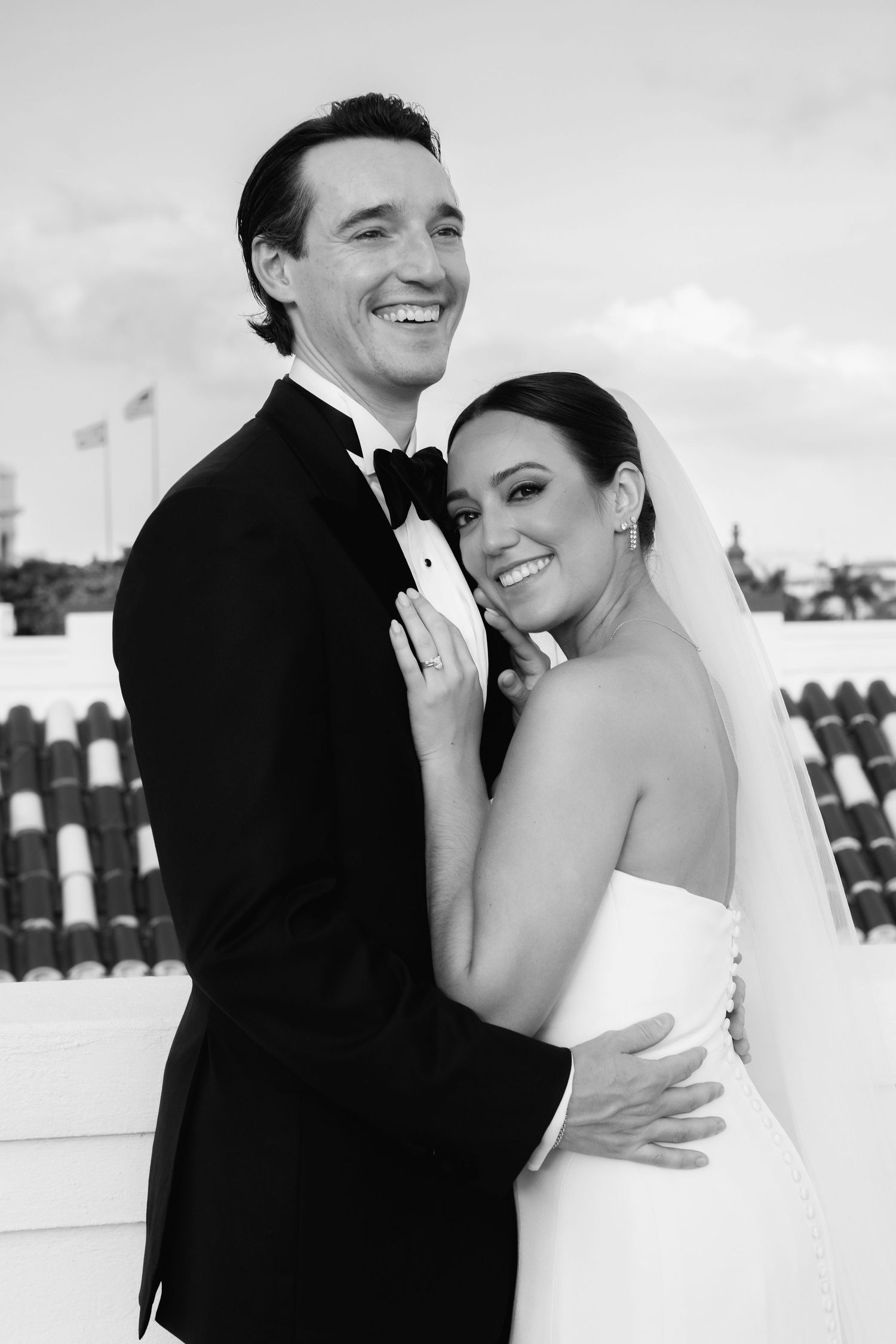 A joyful black and white wedding photo montage showing a bride and groom embracing and laughing together.