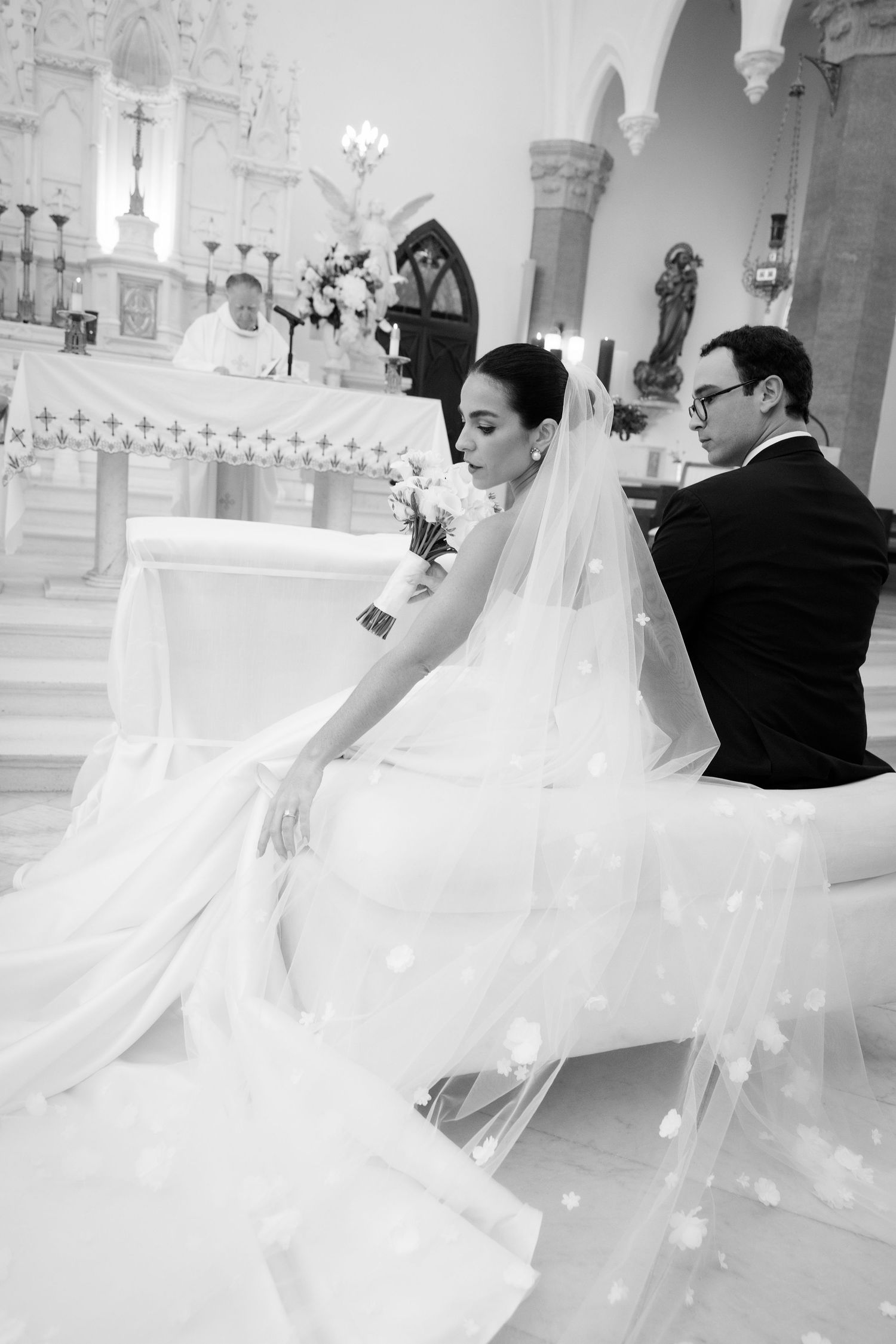 Artistic black and white sequence of newlyweds dancing in a church with flowing wedding dress movement.
